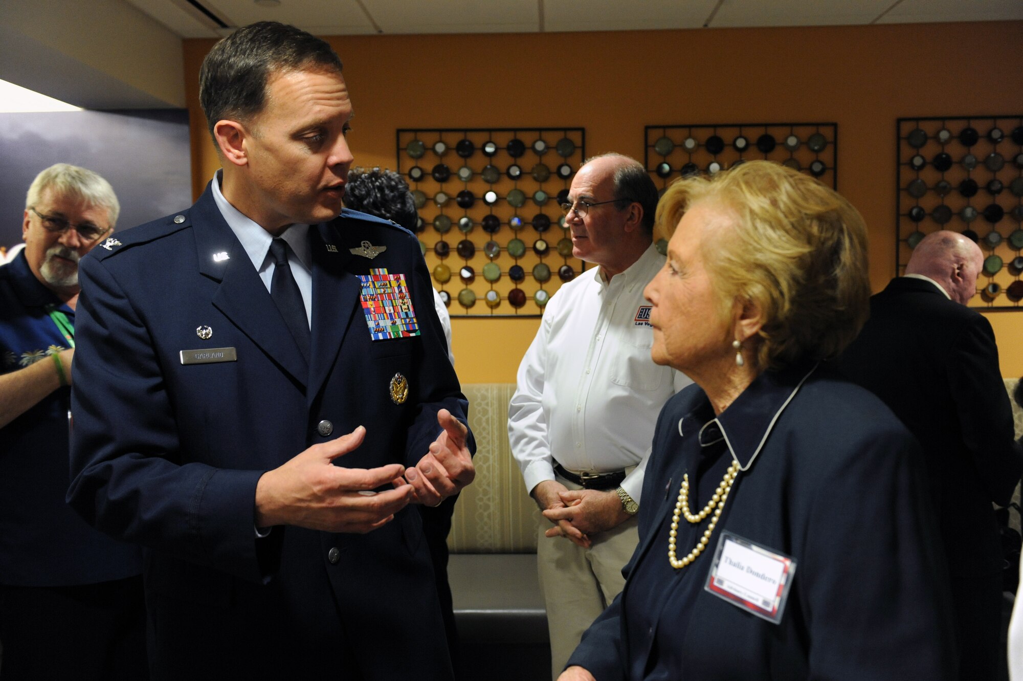 LAS VEGAS -- Col. Steven Garland, 99th Air Base Wing commander, and Thalia Dondero, member of the United Service Organizations board of directors, discuss the opening of the new USO at McCarran International Airport, Nov. 11. All branches of the U.S. military were in attendance of the grand opening. (U.S. Air Force Photo by Senior Airman Brett Clashman/Released)
