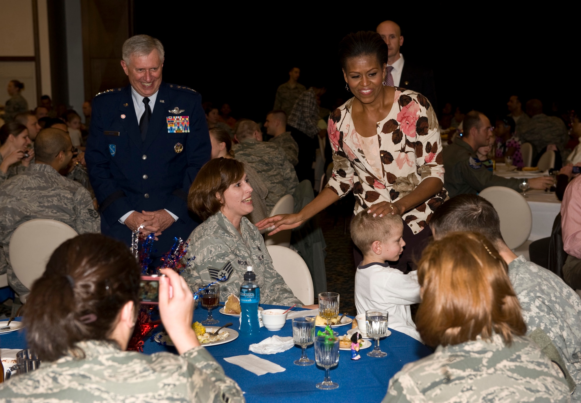 First Lady Michelle Obama and Gen.Roger A. Brady, U.S. Air Forces in Europe commander, visit with servicemembers and their families during a Veterans Day dinner, Ramstein Air Base, Germany, Nov. 11, 2010. The First Lady made a surprise visit to Ramstein during her return from a nine-day tour of Asia to show her support for servicemembers and their families during this Veterans Day. She met with wounded servicemembers at Landstuhl Regional Medical Center, served lunch, talked briefly to the servicemembers and families and met with German first lady Bettina Wulff before flying on to the United States. (U.S. Air Force photo/Tech. Sgt. Wayne Clark) 