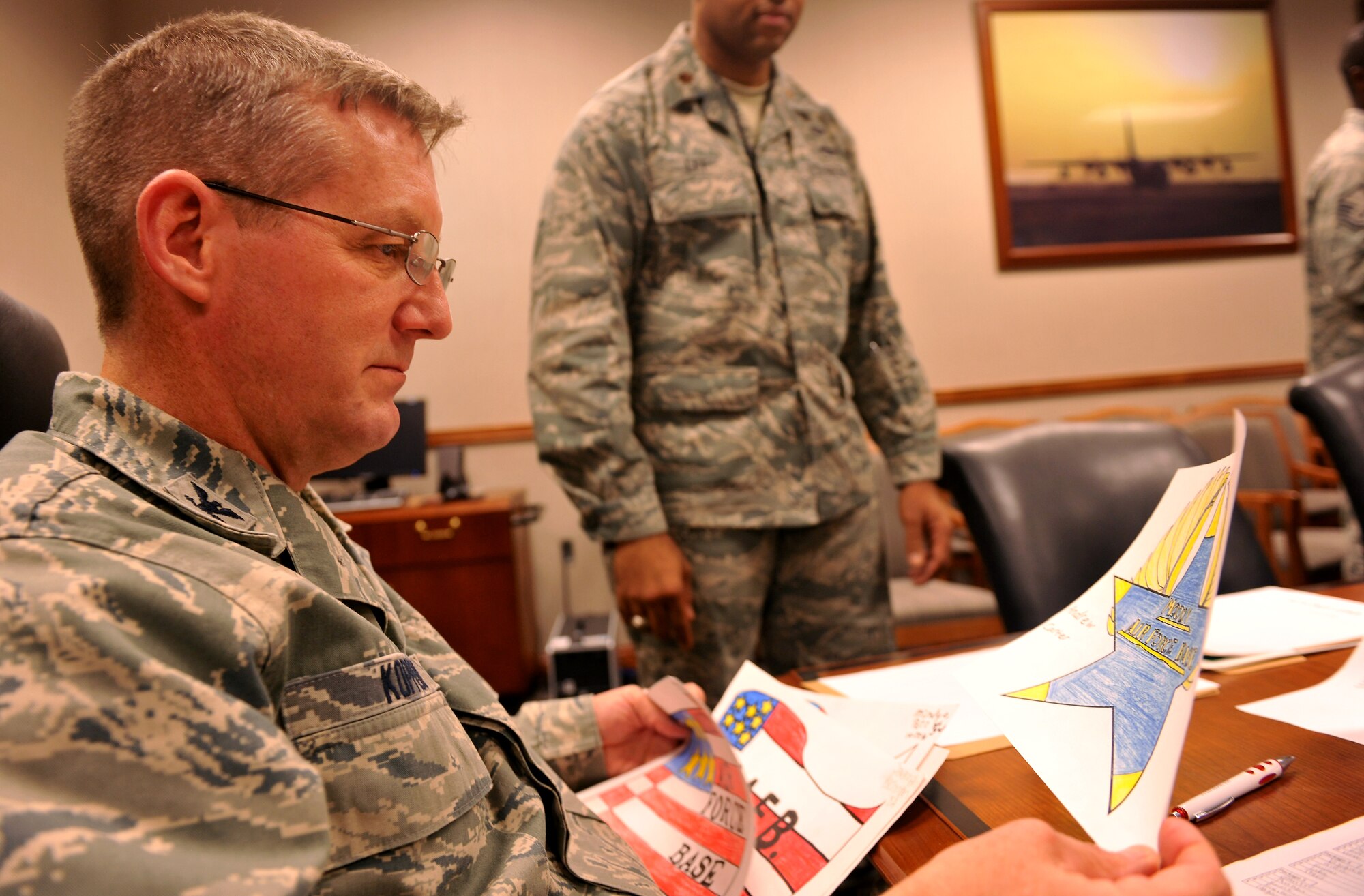 MOODY AIR FORCE BASE, Ga. -- Col. Mark Koppen, 23rd Medical Group commander, looks at two poster submissions for the Airshow LOGO CONTEST during a judging session for the winner here Nov. 9. The number of posters entered for the contest from Lowndes Middle School was more than 60 submissions and took an estimated two hours to judge. (U.S. Air Force photo/Airman 1st Class Joshua Green)(RELEASED)
