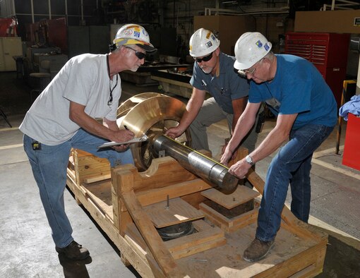 Aerospace Testing Alliance utility machinists, (left to right) Nat Farrar, Reggie Sizemore and David Stewart set the clearance on the new shaft for the recently fabricated impeller before it was installed at the Secondary Pumping Station (SPS). The 25,000 gallon-per-minute impellers are being replaced to help the efficiency and flow of the cooling water that is used throughout the facilities. These SPS pumps, which weigh between five to six tons each, deliver as much as eight billion gallons of water around the base each year to maintain the proper temperatures for conducting tests of jet engines, aircraft models, rocket motors and other flight systems and components. (Photo by Rick Goodfriend)