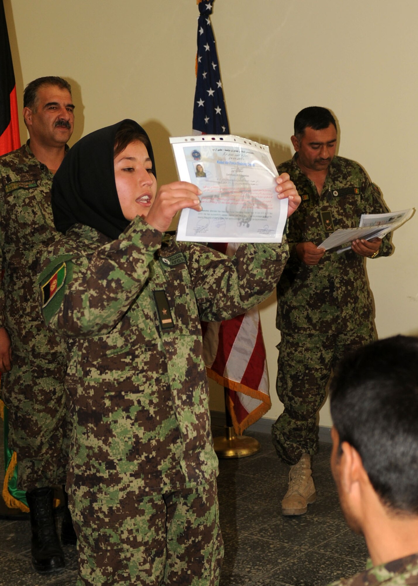 101106-N-6541W-007 KABUL, Afghanistan - 2nd LT. Mahsuma, one of the five female Air Force Lieutenants, presents her graduation certificate to those in attendance at the graduation ceremony. Graduation from this course is the females first step to service in the AAF.  (U.S. Navy photo by Mass Communication Specialist 3rd Class Jared Walker/ RELEASED).