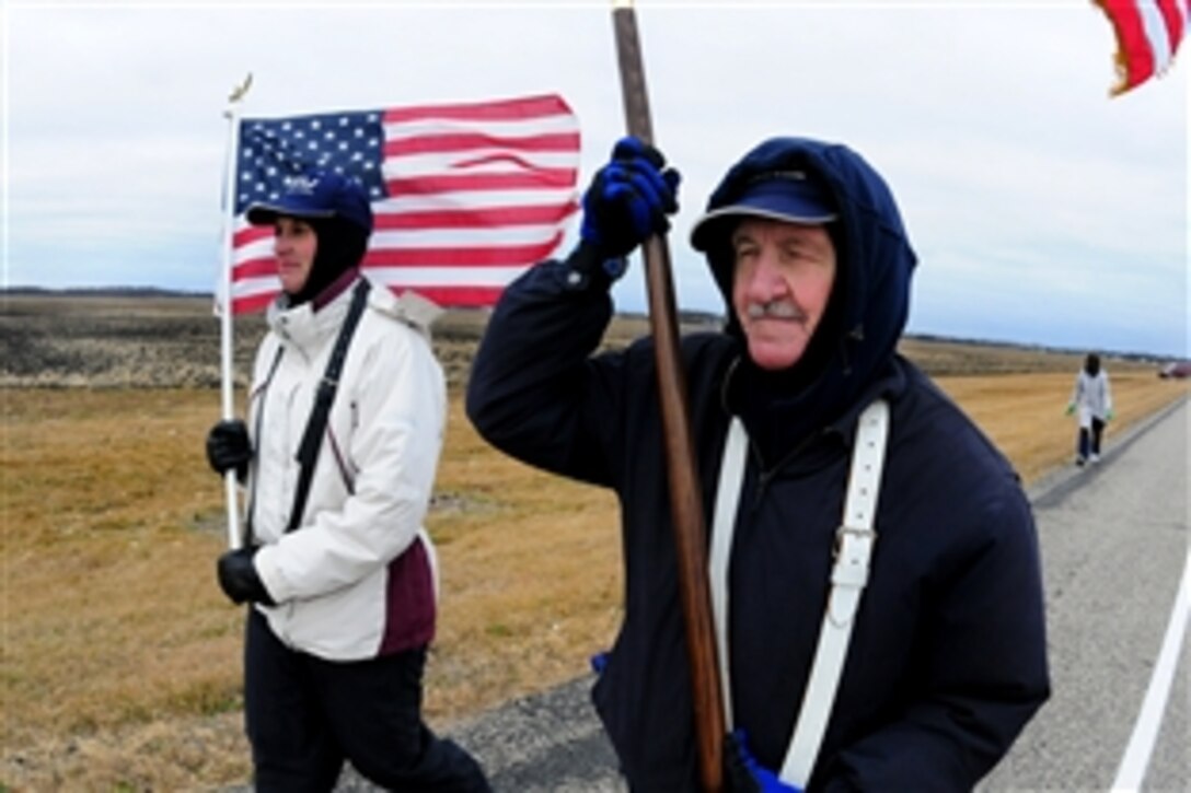 Tom Selleys, right, an 86-year-old World War II veteran, and Terri Schwartz carry the U.S. flag during a 29-mile march from Fargo, N.D., to Abercrombie, N.D., in honor of Veterans Day, Nov. 11, 2010. 