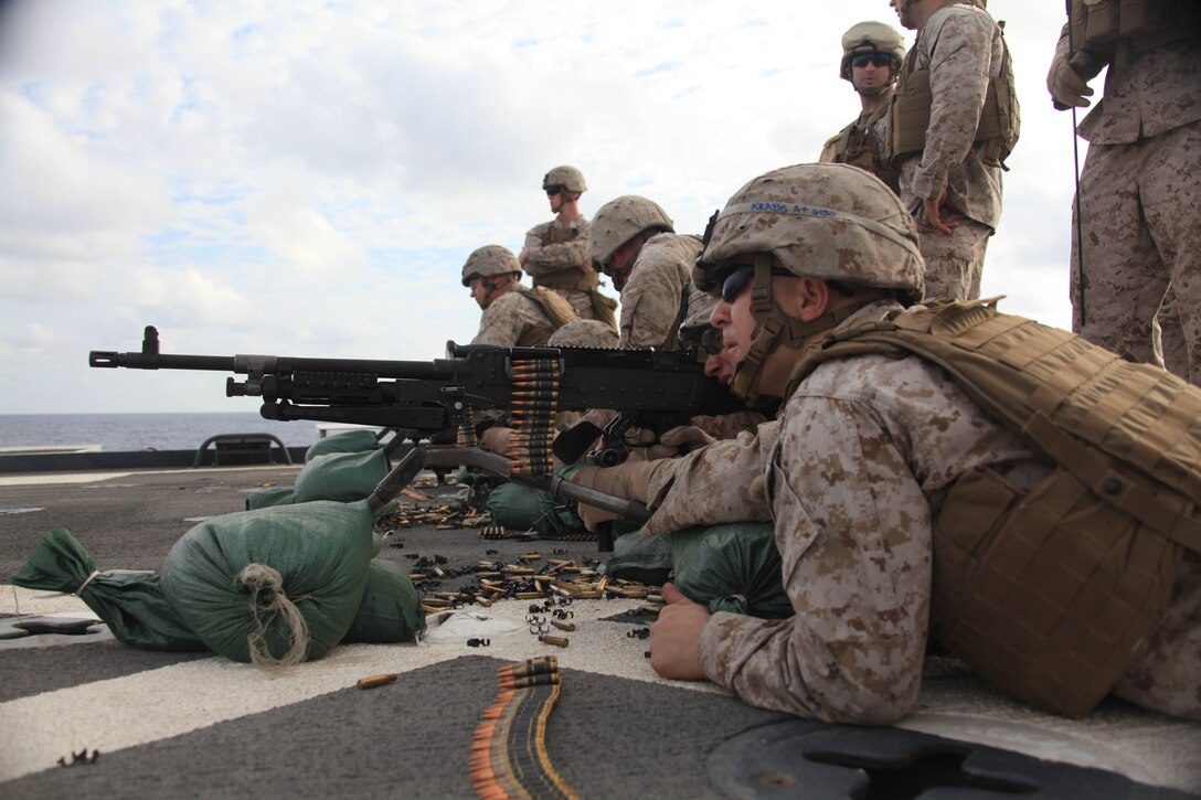 Lance Corporal Clayton Karabas with Weapons Platoon, Company K, Battalion Landing Team 3/8, coaches a Marine during a machinegun live-fire exercise on the flight deck of USS Ponce, Nov. 12, 2010. 26th Marine Expeditionary Unit is currently embarked aboard the ships of Kearsarge Amphibious Ready Group operating in the 5th Fleet area of responsibility. (Official USMC Photo by Staff Sgt. Danielle M. Bacon/ Released) ::r::::n::