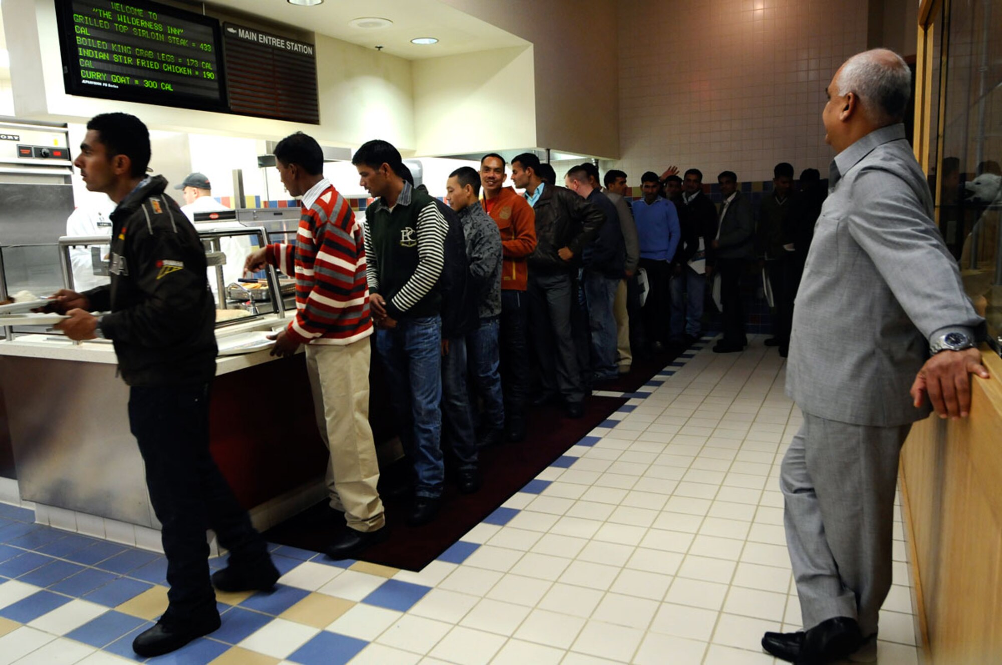 Joint Base Elmendorf-Richardson, Alaska - Mukesh Kumar, Assistant Manager of Carrs-Safeway, Eagle River, looks on as Soldiers from the Indian Army wait in line to sample the many varieties of Indian and American cuisine he prepared for the Diwali festival.   (U.S. Air Force photo/Percy G. Jones)
