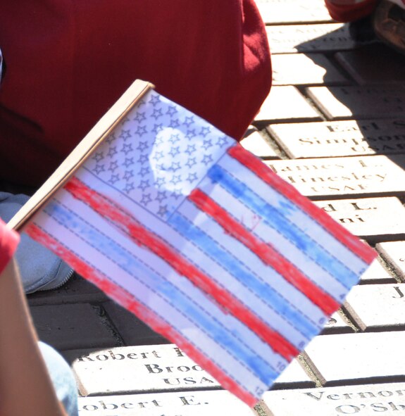 Students from Eglin Elementary participate in the school's annual Veterans Memorial Walk Nov. 10. Students rode a bus to a nearby facility where they met their parents and walked a short distance to Eglin's All Wars Memorial. Students celebrated Veterans Day with patriotic songs and poems. (U.S. Air Force photo/Errica Bennett)