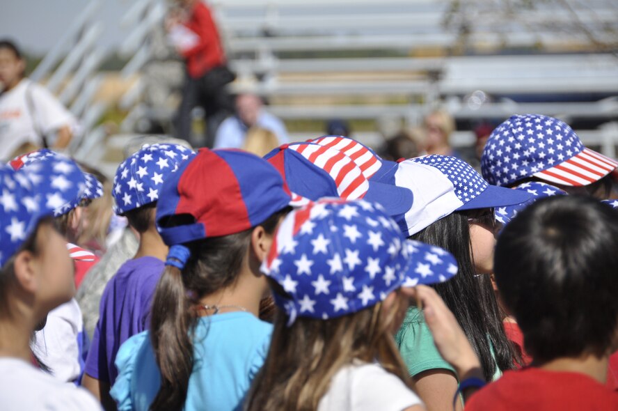 Students from Eglin Elementary participate in the school's annual Veterans Memorial Walk Nov. 10. Students rode a bus to a nearby facility where they met their parents and walked a short distance to Eglin's All Wars Memorial. Students celebrated Veterans Day with patriotic songs and poems. (U.S. Air Force photo/Errica Bennett)