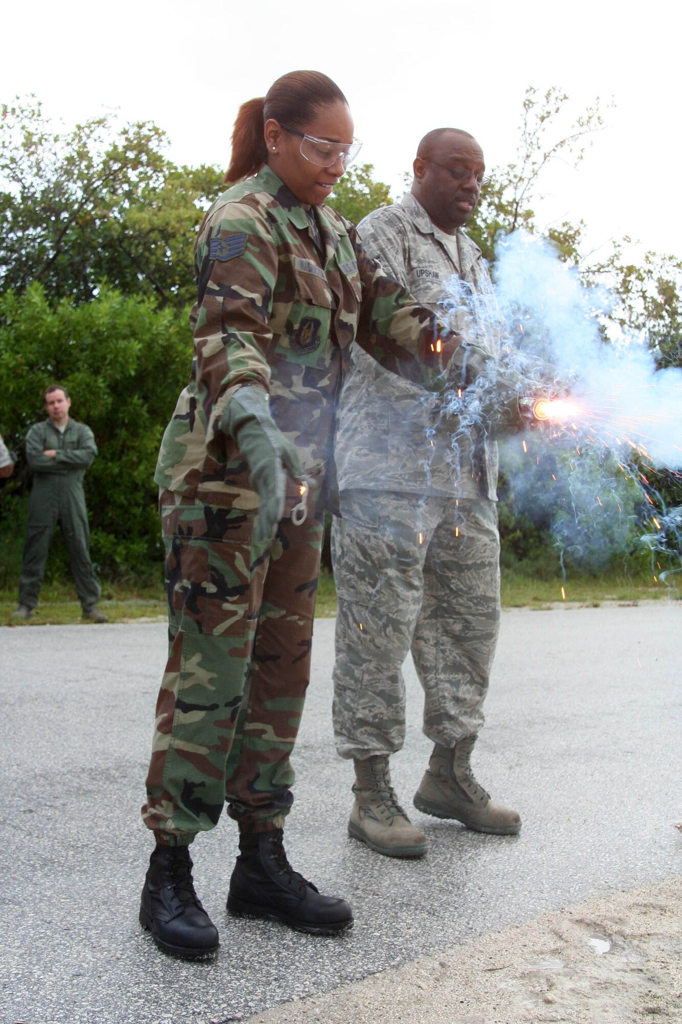 WRIGHT-PATTERSON AIR FORCE BASE, Ohio - Staff Sgt. Cassie Washington pulls the pin on an MK-13 day/night flare under the watchful eye of Tech. Sgt. Maurice Upshaw, both from the 445th Operation Support Squadron.  More than 75 reservists from the 445th Airlift Wing conducted annual water survival training requirements at the Naval Air Station in Key West, Fla., Oct. 13-16. (U.S. Air Force Photo/Capt. Rod McNany)