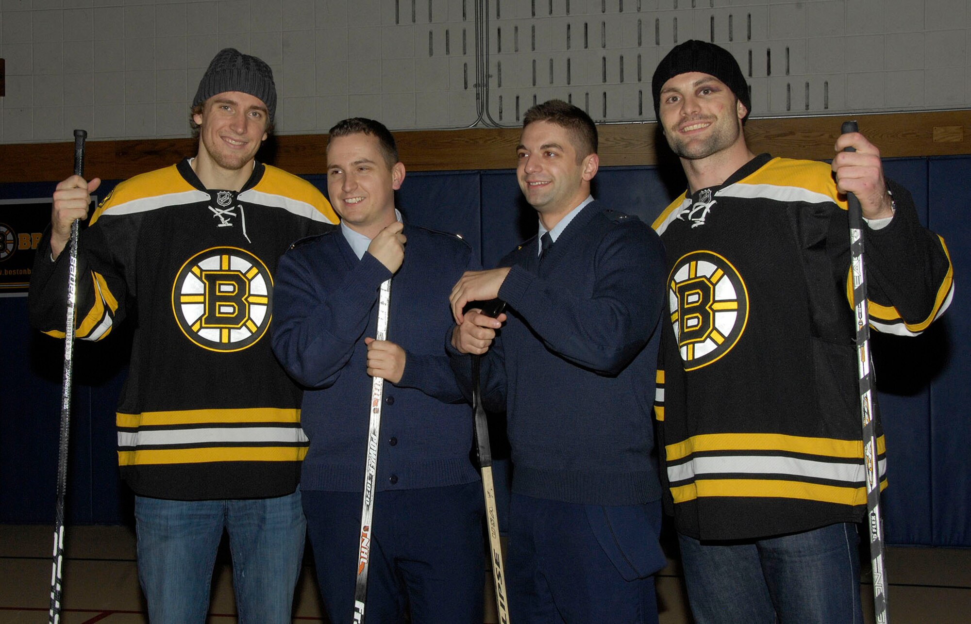 HANSCOM AIR FORCE BASE, Mass. – Blake Wheeler and Mark Stuart (left and right) pose with Staff Sgt. Sean Germain and Airman 1st Class Todd Olsson from the 66th Medical Squadron during their visit to Hanscom on Nov. 8 for a hockey clinic. Both Wheeler and Stuart donated $5,000 worth of tickets for local military families to attend the Bruins hockey game on Nov. 15. Military families interested in tickets may visit www.uso-newengland.org or call 617-720-4949. (U.S. Air Force photo by Linda LaBonte Britt)