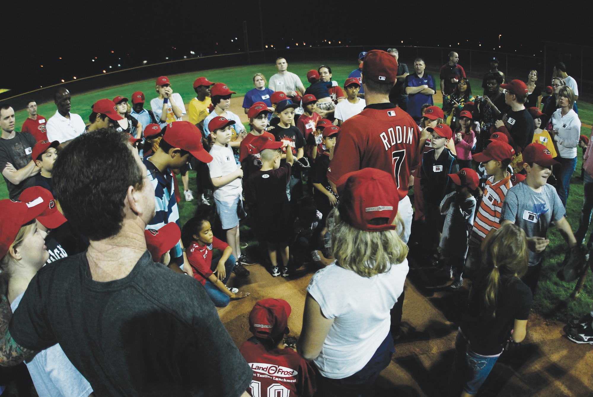 Parents, children and Diamondback coaches gather at the center for closing remarks at the end of the Arizona Diamondbacks Baseball Clinic held at Luke Air Force Base, Arizona.  (U.S. Air Force photo/Austin Thomas)
