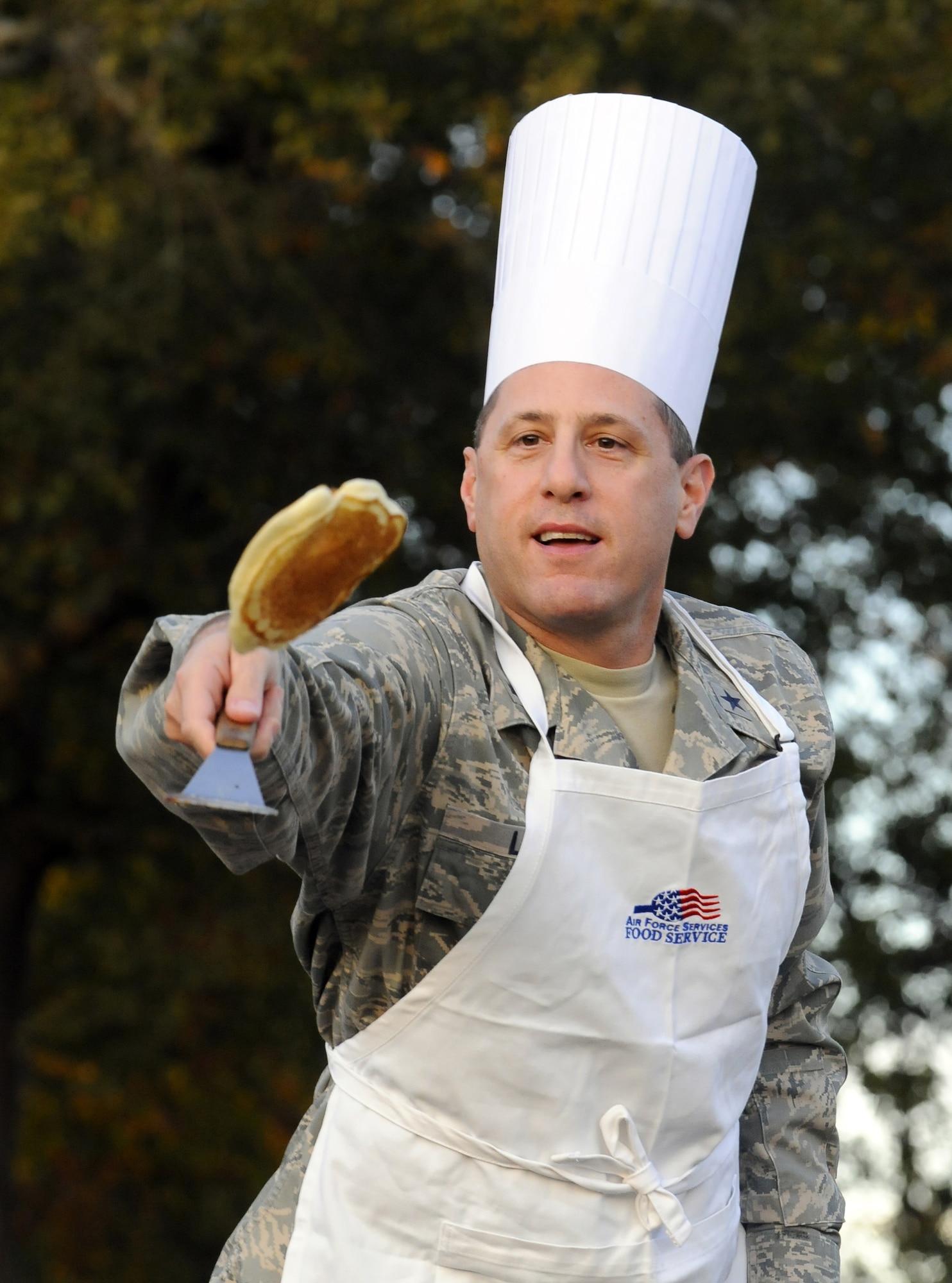Gen. Lee Levy flips a pancake to the crowd at the 2nd Annual Pancake Flip Nov. 10. U. S. Air Force photo by Sue Sapp
