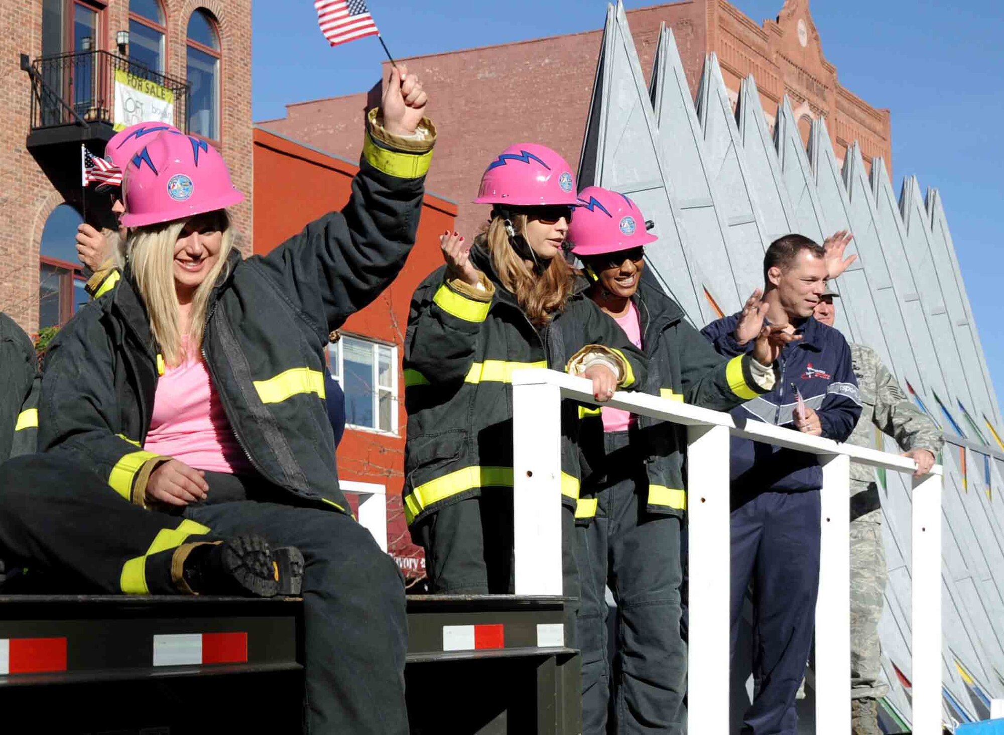 Airmen with the Air Force Academy Fire Department wave to spectators during the Colorado Springs Veterans Day Parade Nov. 6, 2010. The women in pink helmets are members of the "Fire Fembots" Firefighter Combat Challenge team, the defending world champions in the Firefighter Combat Challenge women's relay. (U.S. Air Force photo/Johnny Wilson)