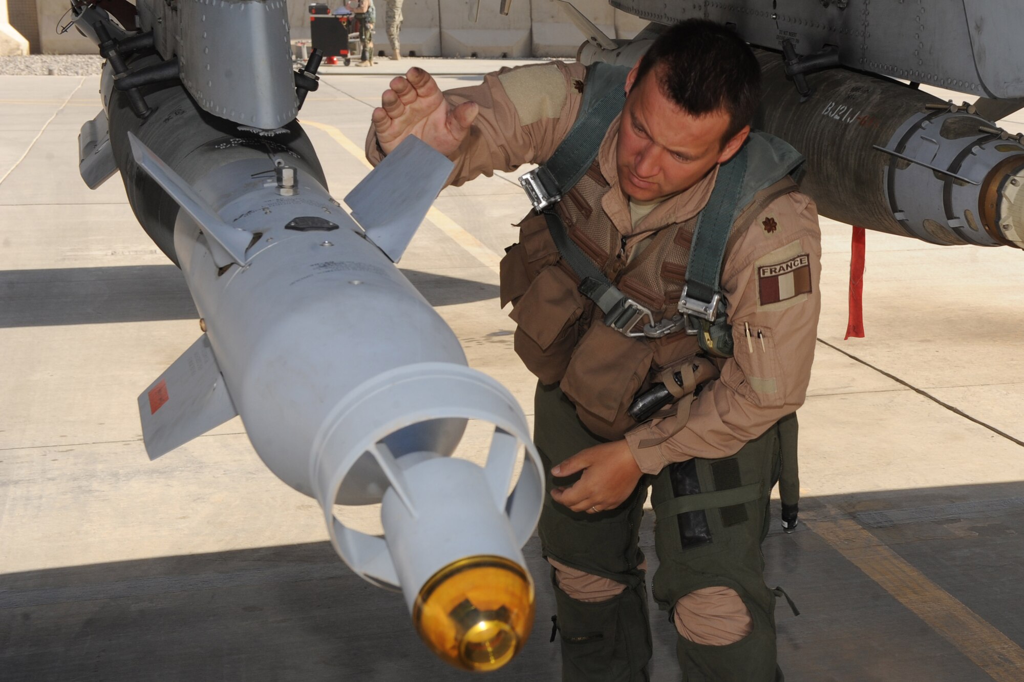 French Air Force Maj. Yann Malard inspects a piece of ordnance on the A-10C Thunderbolt II, Nov. 26, 2010, at Kandahar Airfield, Afghanistan. Major Malard from Nancy, France, is an assistant duty officer with the 75th Expeditionary Fighter Squadron. Major Malard is deployed with the American unit as part of the three-year foreign exchange pilot program. (U.S. Air Force photo by Tech. Sgt. Chad Chisholm/Released)