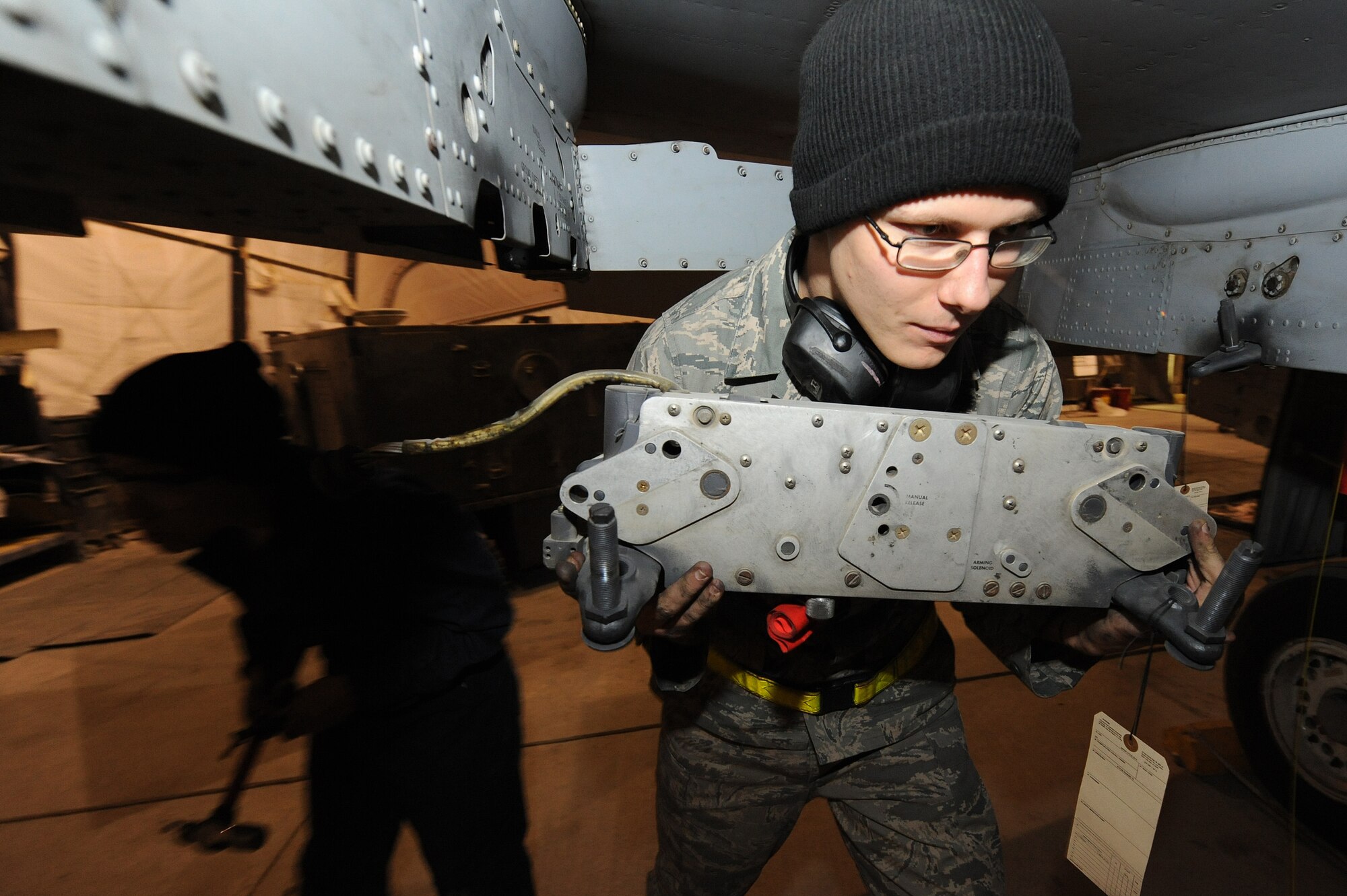 Airman 1st Class Douglas Howe carries a bomb rack from a pylon on an A-10C Thunderbolt II during a phase inspection Nov. 10, 2010, at Kandahar Airfield, Afghanistan. Airman Howe from, St. Charles, Mich., is an aircraft armament systems apprentice assigned to the 451th Expeditionary Maintenance Squadron A-10 Aircraft Maintenance Unit. (U.S. Air Force photo by Tech. Sgt. Chad Chisholm/Released) 