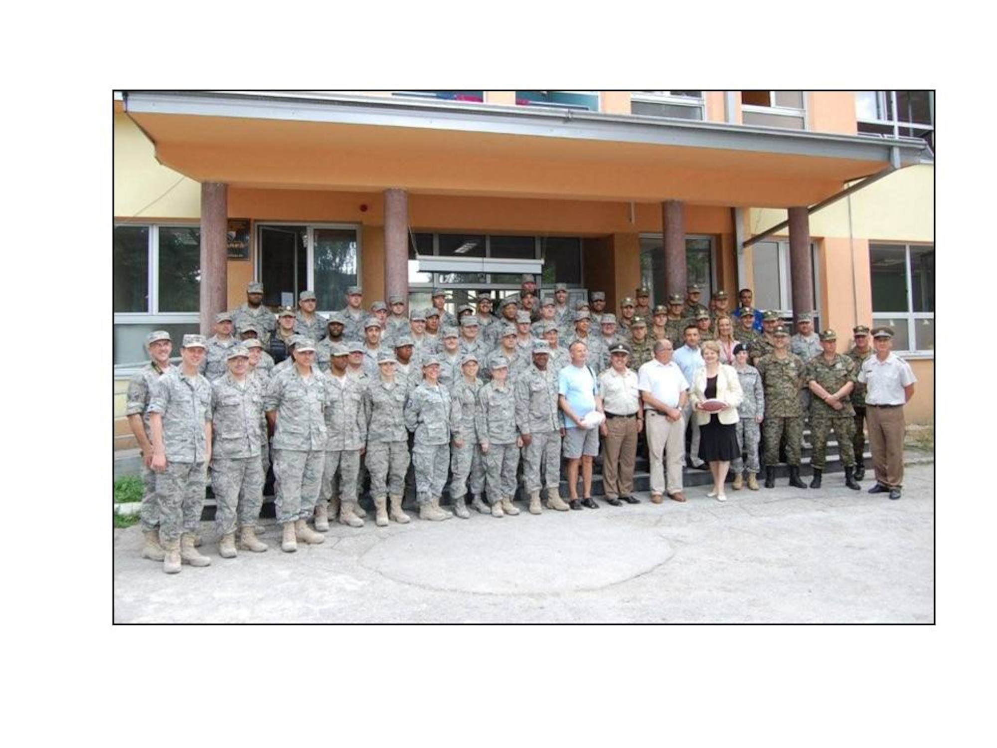 136th Civil Engineering Squadron, Texas Air National Guard, Bosnian Officials and friends pose in front of the school the unit help renovate along with (right to left) members of the Bosnian military, staff of the Office of Defense Cooperation, Vice-Principal, Mayor, General Puljic, and Principal. (Courtesy photo by 136 CES)