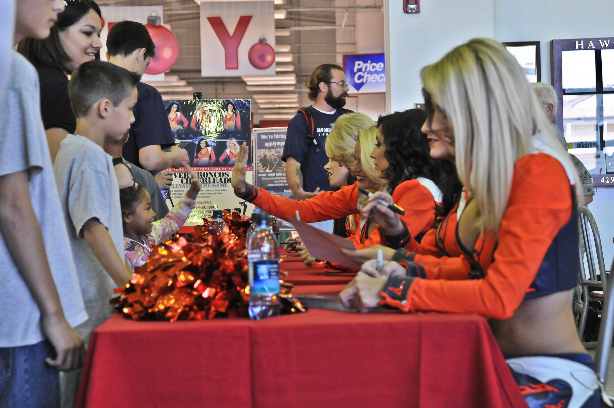 Denver Broncos cheerleaders sign autographs and take photos with Incirlik patrons at the Base Exchange Nov. 5, 2010 at Incirlik Air Base, Turkey. The cheerleaders made several morale and educational appearances around the base including a radio show with the Incirlik Armed Forces Network, a cheer clinic with children at the youth center, met with Security Forces Airmen and ended with a performance at the consolidated club. (U.S. Air Force photo by Senior Airman Alexandre Montes/Released)  