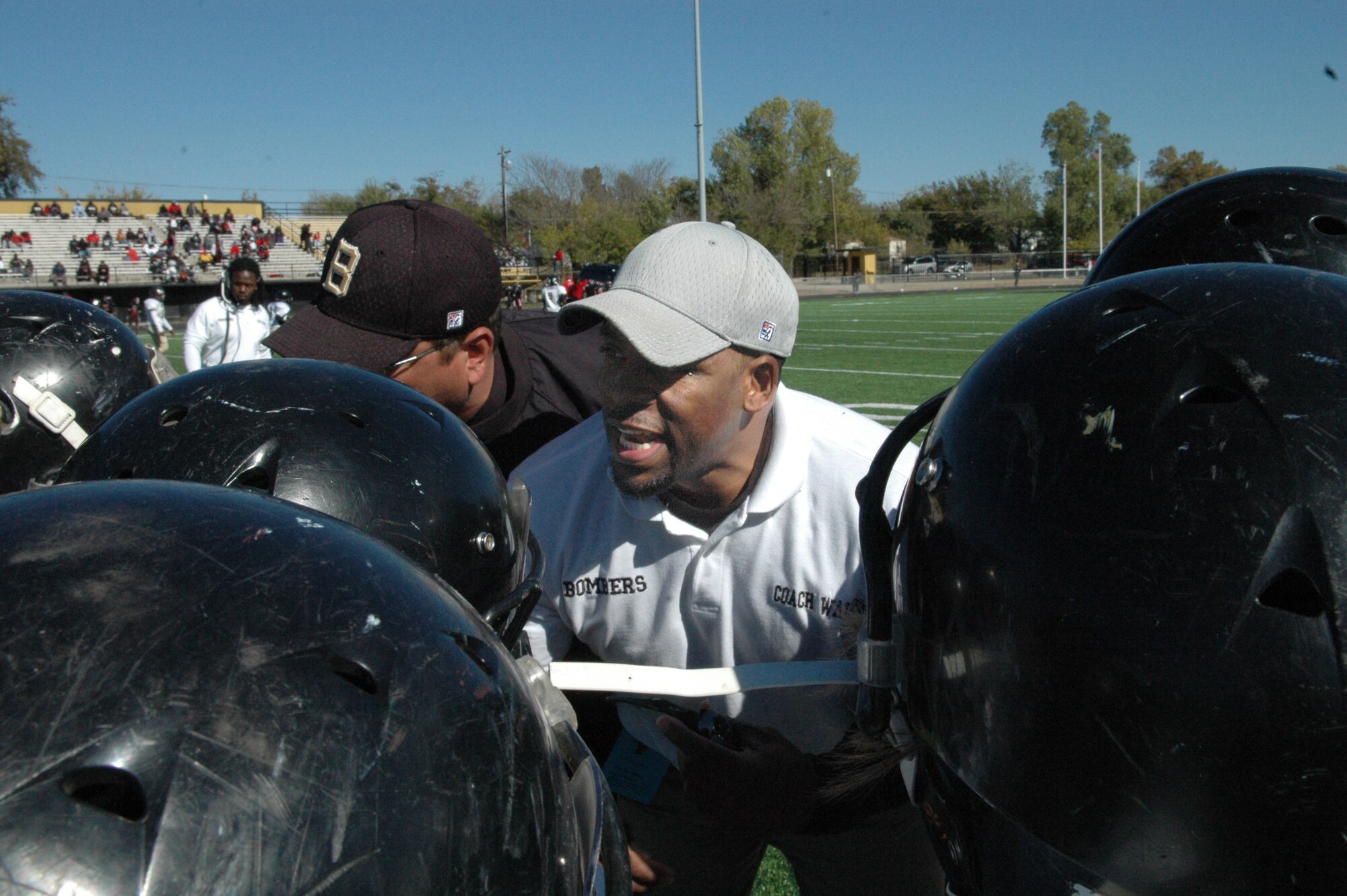 Tracy Walker, a recreation assistant with the 72nd Force Support Squadron, spends his free time coaching the Midwest City Bombers youth football team. Tracy is motivating his team during a tough battle with the Truth, a team from the youth program coached by former NFL player Deion Sanders. (Air Force photo by Micah Garbarino)