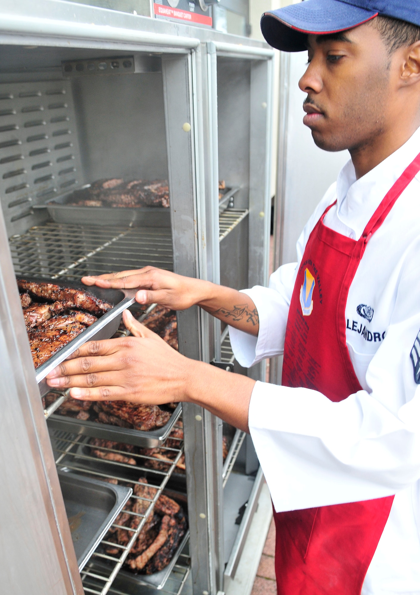 U.S. Air Force Senior Airman Dexter Alejandro, 86th Services Squadron places steaks in a warmer during a Veteran's day observance dinner at the Ramstein Officer's Club, Ramstein Air Base, Germany, Nov. 11, 2010. Cooks of the Valley served 13,500 complimentary steakes to America’s uniformed men, women and their family members to show their support. (U.S. Air Force photo by Airman 1st Class Desiree Esposito)
