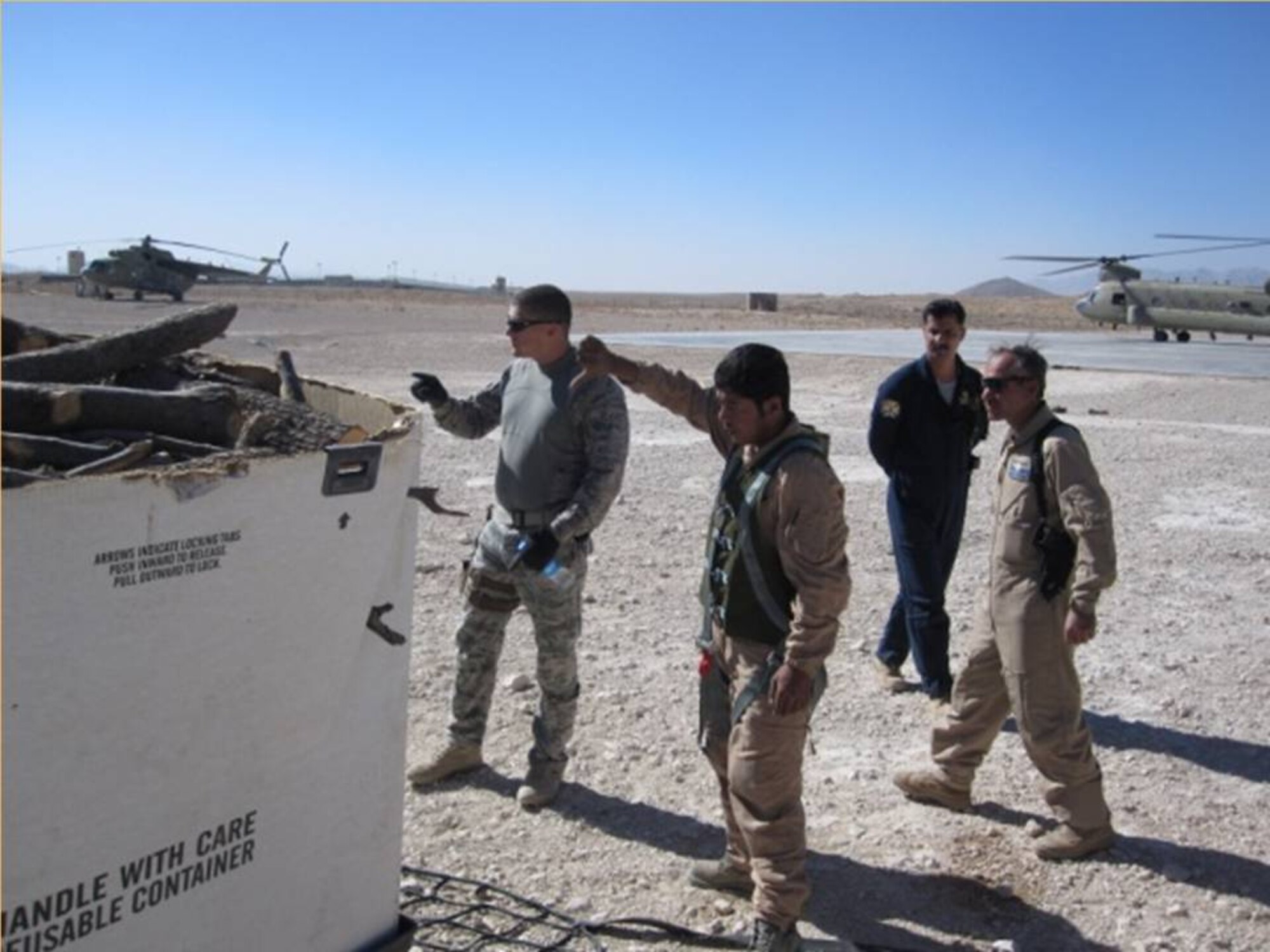 KANDAHAR, Afghanistan – NATO Air training Command – Afghanistan advisors & Kandahar Air Wing Flying Crew Chiefs worked side-by-side to safely configure the sling loads for flight on Nov. 9.  (U.S. Air Force photo/RELEASED).