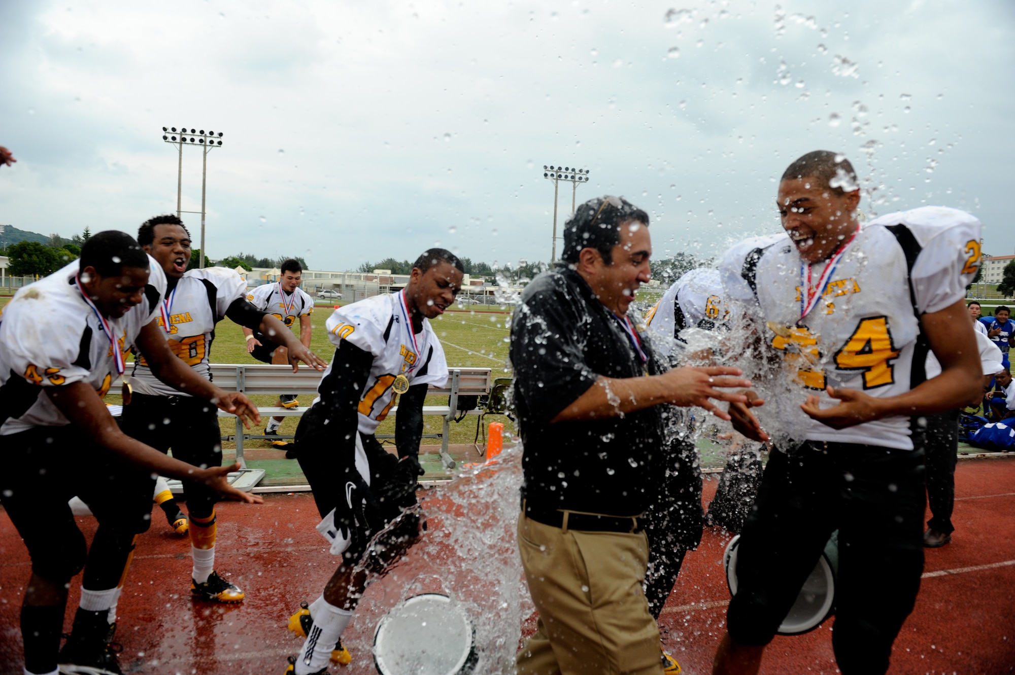 Kadena High School Panthers drench head coach Sergio Mendoza with water after their team won the DoDEA Pacific Far East Football Championship Nov 12. The Kadena Panthers beat the Yokota Panthers 50-23 for the title. (U.S. Air Force photo/Staff Sgt. Jonathan Steffen)
