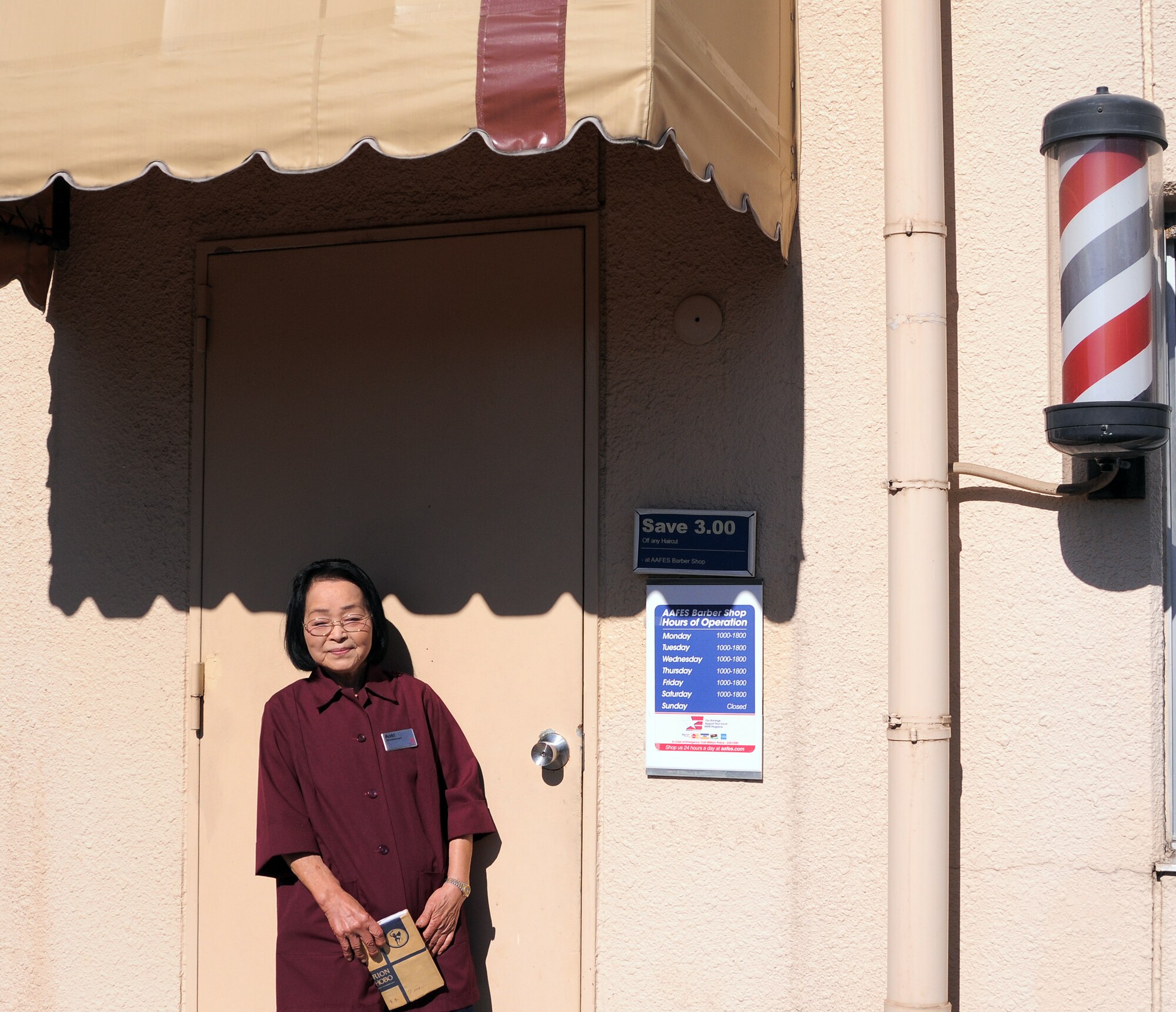 YOKOTA AIR BASE, Japan -- Toshiko Aoki-san, who has been an AAFES barber for 59 years and worked at Yokota Air Base for 40 of those years, opens the shop she runs at the Officers' Club after a Cherry Blossom Tree Dedication Ceremony, here Nov. 10. (U.S. Air Force Photo/ Airman 1st Class Katrina R. Menchaca)