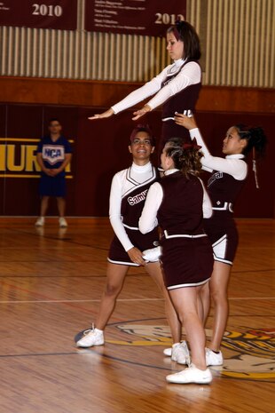 Matthew C. Perry High School Samurai cheerleaders Karly Chambers, Patricia Mojica, Lydia Pierce and Destynee Santiago prepare for a stunt as part of their team routine during the final competition of the National Cheerleading Association cheerleading clinic held at the Matthew C. Perry High School gymnasium here Nov. 12.