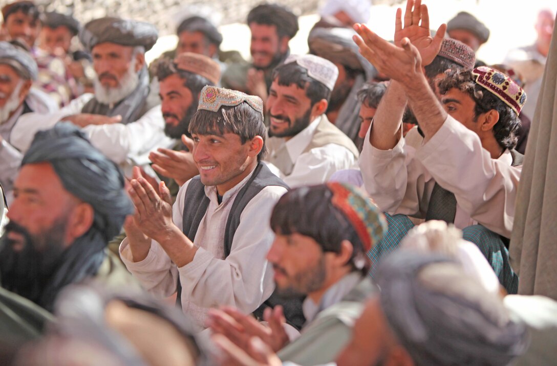 Local Afghans clap and cheer after listening to Al Haj Haji Merdel, an Islamic religious scholar and respected holy man, during shura at Marine Corps Forward Operating Base Camp Hansen, Marjah, Afghanistan, Nov. 13, denouncing the Taliban’s use of Jihad as a justification for years of war and fighting in Afghanistan. Helmand Province government officials, along with local holy men, said the Taliban was using Jihad as a false pretext to fight foreign nations in Afghanistan.