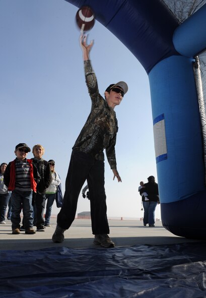 MOODY AIR FORCE BASE, Ga. -- Dylan Henderson, son of Todd and Malisa Wildes, throws a football at a target during Moody’s Community Appreciation Day Air Show Nov. 13. Several games and attractions were set on display for the children to enjoy during the air show. (U.S. Air Force photo/Airman 1st Class Benjamin Wiseman)(RELEASED)