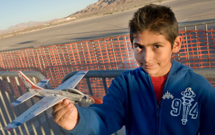 NELLIS AIR FORCE BASE, Nev.--  Jorge Osorio holds up his model Thunderbird airplane during the 2010 Aviation Nation Nellis Open House Nov. 12. The Open House is an opportunity for the Las Vegas community to view aerial demonstrations and static displays of various aircraft from the military. The open house also acts as the final air show of the year for the  U.S. Air Force Air Demonstration Squadron "Thunderbirds." (U.S Air Force Photo / Senior Airman Stephanie Rubi (Released)