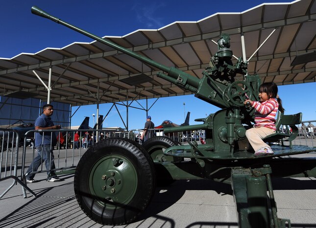 NELLIS AIR FORCE BASE, Nev. --  Cali Best sits on an Anti Air flak-cannon during the 2010 Aviation Nation Nellis Open House Nov. 12. The Nellis Open House is an opportunity for the Las Vegas community to view aerial demonstrations and static displays of various aircraft from the military. The open house also acts as the final air show of the year for the  U.S. Air Force Air Demonstration Squadron "Thunderbirds." (U.S. Air Force photo by Senior Airman Brett Clashman)(Released)
