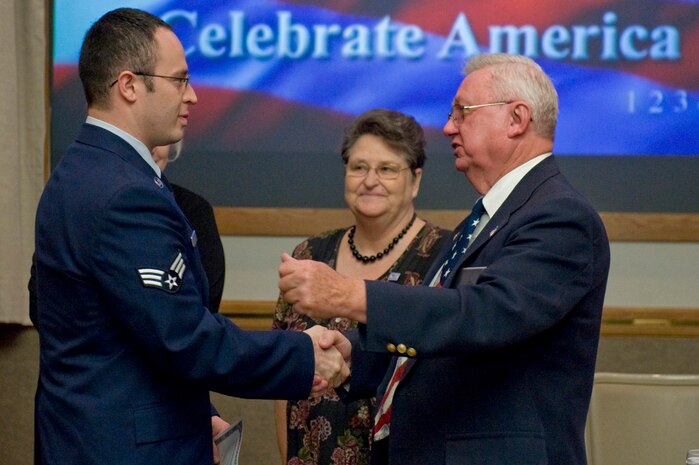 NELLIS AIR FORCE BASE, Nev.-- Senior Airman Mark Houston, of the 99th Force Support Squadron, shakes hands with Wayne Leroy, Trustee of the Benevolent order of the Elks, after the Special Naturalization Ceremony at the Nellis Officer's Club, Nov. 12, 2010. People representing 12 different countries became United States citizens. (U.S. Air Force Photo by Airman 1st Class Jamie Nicley/Released)