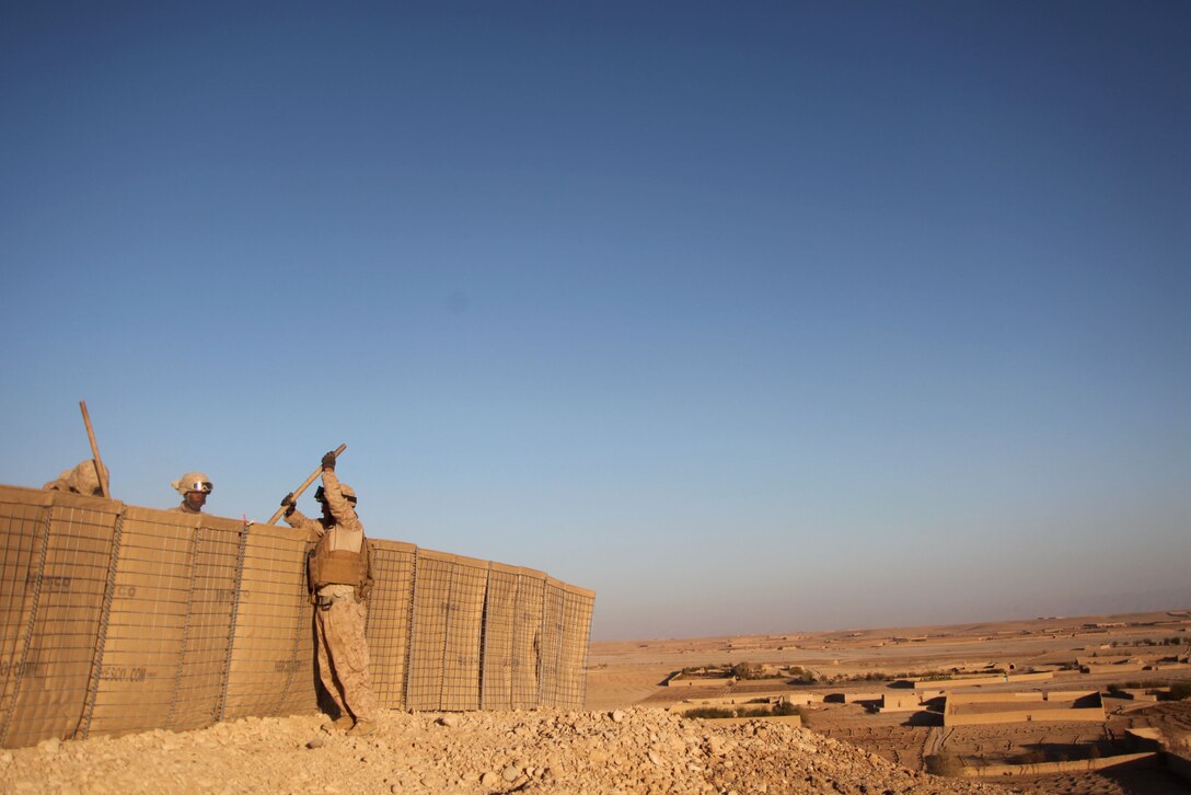 Engineers with 1st Combat Engineer Battalion, 1st Marine Division (Forward), fill Hesco barriers at a new combat outpost in Musa Qal’eh, Nov. 13, 2010. Afghan forces were in need of a defensive position due to enemy activity in a near by town.