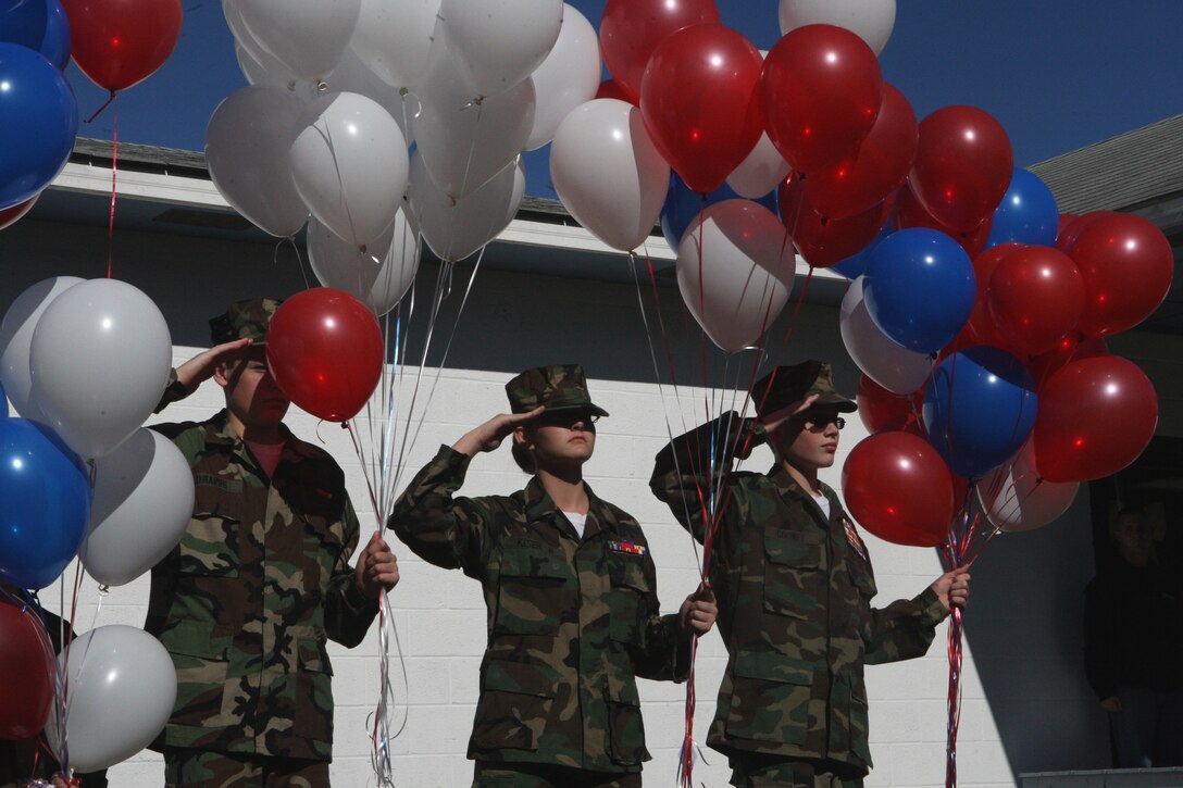 A detail of Swansboro Young Marines salute a passing color guard as they hold a total of 107 balloons with the names of local veterans tied to the ends during the 6th annual Veterans Appreciation Spaghetti Dinner at the Woodsmen of the World Lodge 1405, Nov. 14. These two events are part of the annual veterans appreciation week where the Young Marines must hold three events that honor military veterans.