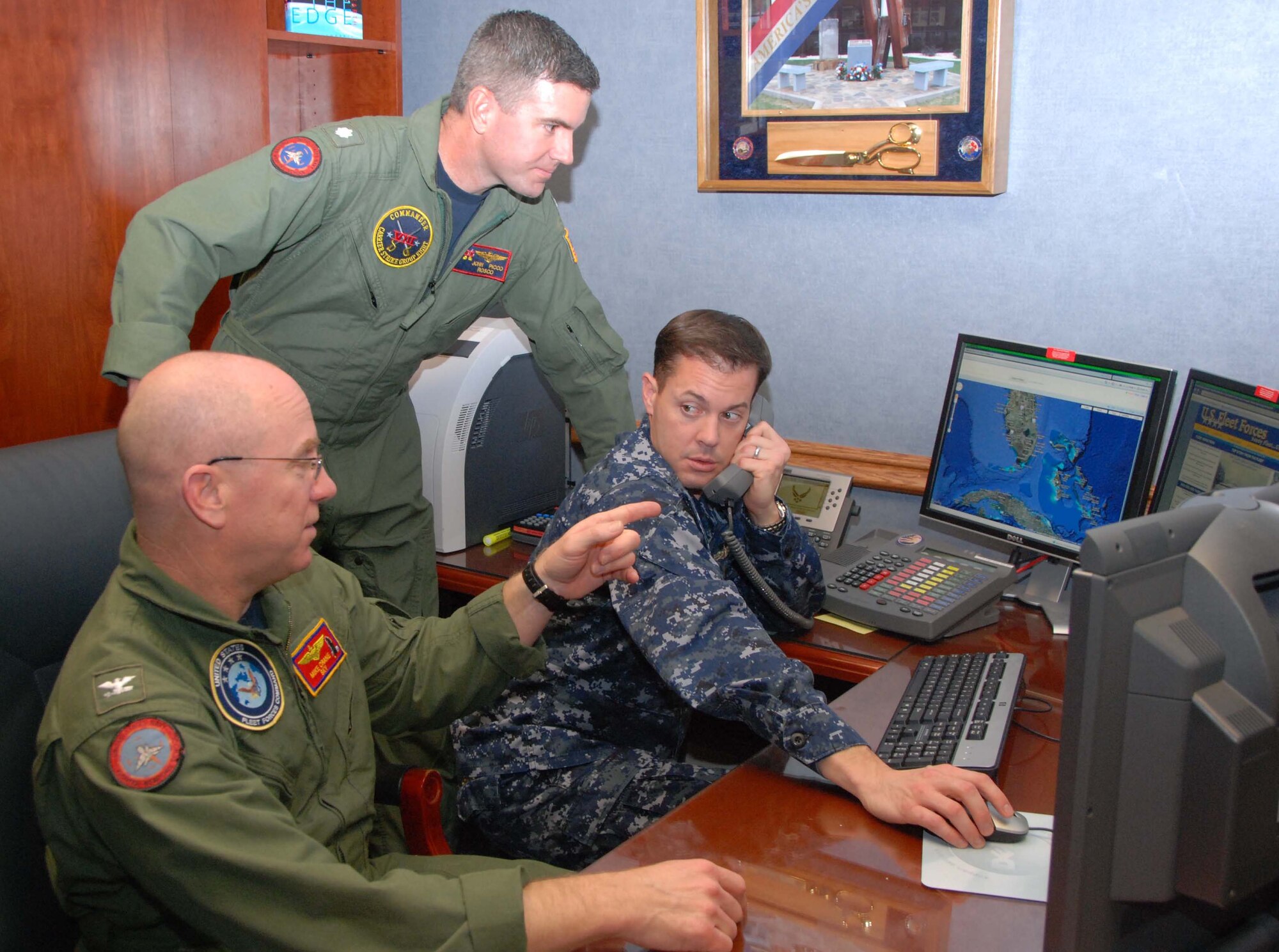 Navy Capt. Mike Crane (from left) discusses training objectives with Cdr. John Picco and Lt. Cmdr. Joel Lang during Vigilant Shield ’11, a NORAD and U.S. Northern Command exercise that ensures the interoperability of numerous Defense Department assets in support of the president’s national security strategy. The three-man Navy team worked as the Navy liaison element for Air Forces Northern, USNORTHCOM’s air component, based at Tyndall Air Force Base, Fla. (U.S. Air Force photo/Capt. Jared Scott)