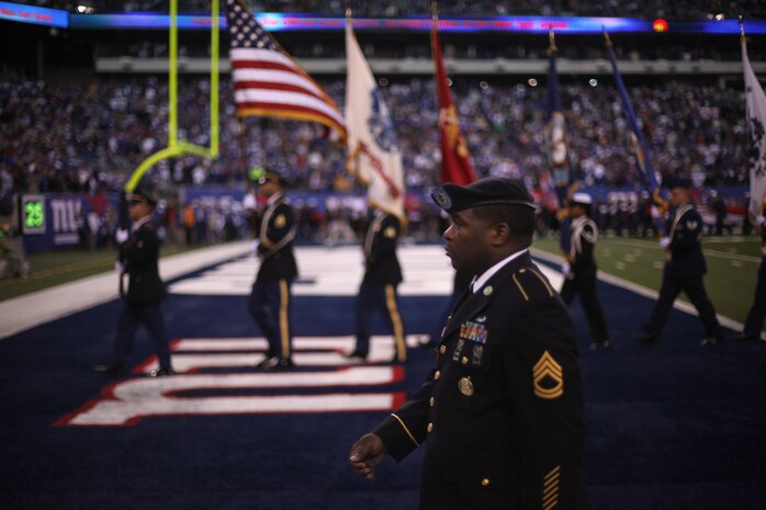 A joint service color guard marches off the field along with Marines, sailors, coast guardsmen and soldiers at the conclusion of a presume ceremony at the New York Giants military appreciation game versus the Dallas Cowboys, Nov 14.