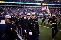 Marines, sailors, coast guardsmen and soldiers march off the field after a large American flag was presented across the field at the New York Giants military appreciation game versus the Dallas Cowboys, Nov. 14.
