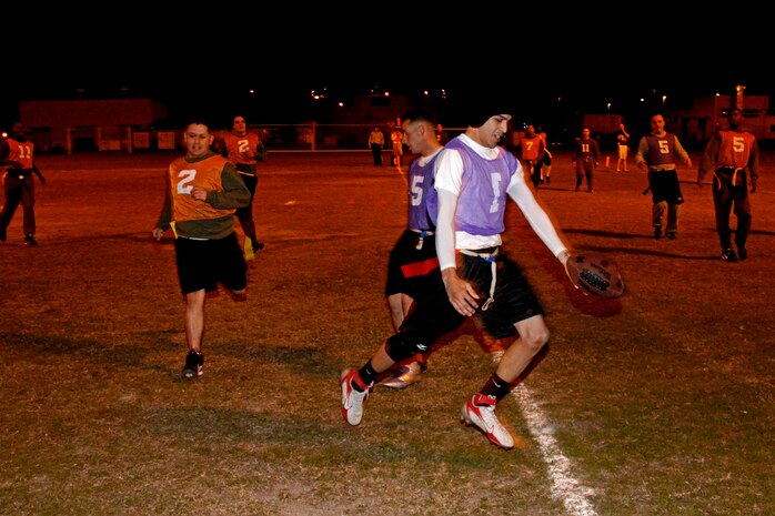 Paul Torres, quarterback for Da Freaks, holds the ball out for a touchdown after a ten-yard scramble during an Intramural Flag Football game at the Penny Lake football field here Monday. Da Freaks blew the Wreckin’ Crew out of the water with a 37-19 beat down before the game was called due to the mercy rule.