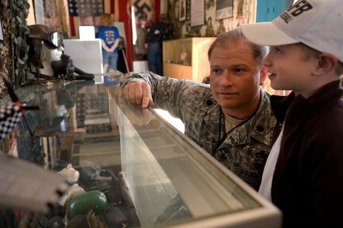 NELLIS AIR FORCE BASE, Nev.--  Lt. Col. Shane Henderson, 757th Aircraft Maintenance Squadron commander, and his son J.T. Henderson look through the World War II exhibit at the 2010 Aviation Nation Nellis Open House Nov. 14. The Nellis Open House is an opportunity for the Las Vegas community to view aerial demonstrations and static displays of various aircraft from the military. The open house also acts as the final air show of the year for the U.S. Air Force Air Demonstration Squadron, "Thunderbirds." (U.S Air Force Photo / Senior Airman Stephanie Rubi) (Released)
