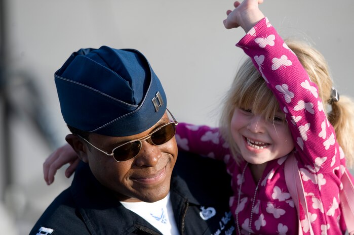 NELLIS AIR FORCE BASE, Nev. -- Capt. Jason McCree, Public Affairs officer with the U.S. Air Force Air Demonstration Squadron, the Thunderbirds, holds Lucy Gallemore during the 2010 Aviation Nation Nellis Open House Nov. 14. The Nellis Open House is an opportunity for the Las Vegas community to view aerial demonstrations and static displays of various aircraft from the military. The open house also acts as the final air show of the year for the U.S. Air Force Air Demonstration Squadron, "Thunderbirds." (U.S. Air Force photo by Senior Airman Brett Clashman)(Released)