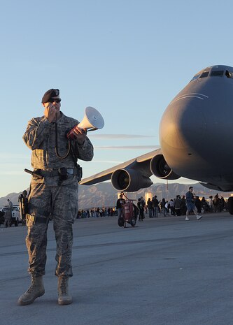 NELLIS AIR FORCE BASE, Nev.--  Master Sgt. Dustin Kingland, 99th Security Forces Squadron flight chief, directs pedestrians to the exits as the 2010 Aviation Nation Nellis Open House came to an end Nov. 14. The Nellis Open House was an opportunity for the Las Vegas community to view aerial demonstrations and static displays of various aircraft from the military. The open house also acts as the final air show of the year for the U.S. Air Force Air Demonstration Squadron, "Thunderbirds." (U.S Air Force Photo / Airman 1st Class Matthew Lancaster) (Released)