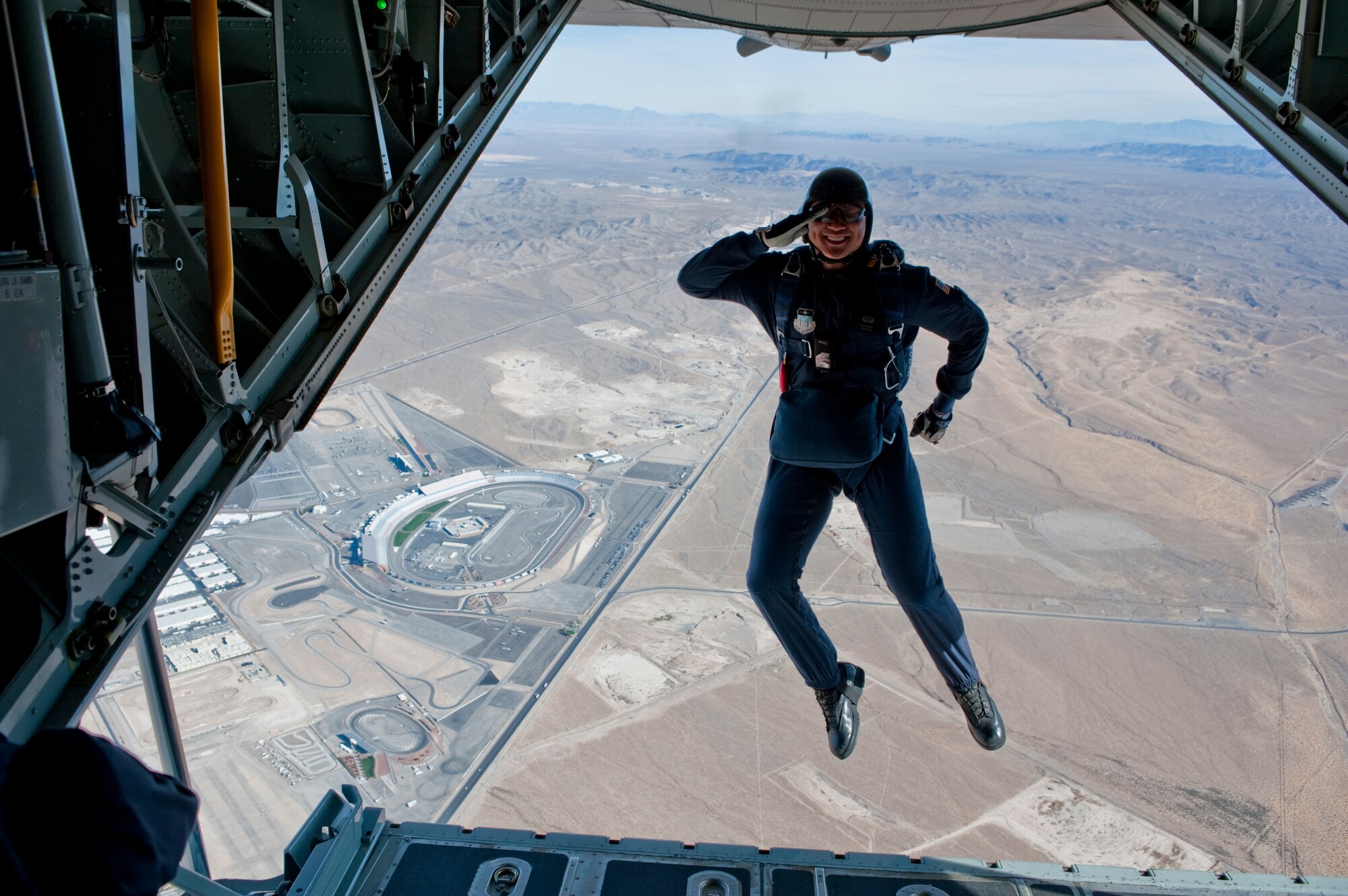 NELLIS AIR FORCE BASE, Nev. --  U.S. Air Force Academy Cadet 1st Class Alan Wong with the  U.S. Air Force Academy parachute team, Wings of Blue, salutes as he exits the back of a C-130 Hercules during the 2010 Aviation Nation Nellis Open House Nov. 14. Cadet 1st Class Alan Wong is senior at the Air Force Academy and is currently slated to become a pilot upon graduation. The Nellis Open House is an opportunity for the Las Vegas community to view aerial demonstrations and static displays of various aircraft from the military. The Nellis Open House is an opportunity for the Las Vegas community to view aerial demonstrations and static displays of various aircraft from the military. The open house also acts as the final air show of the year for the  U.S. Air Force Air Demonstration Squadron "Thunderbirds." (U.S. Air Force photo by Tech. Sgt. Michael R. Holzworth)(Released)
