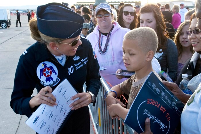 NELLIS AIR FORCE BASE, Nev. -- Capt. Petrina Hanson, U.S. Air Force Air Demonstration Squadron "Thunderbirds,"  Executive Officer, signs an autograph for a young fan on Nov. 14, 2010. The Nellis Open House is an opportunity for the Las Vegas community to view aerial demonstrations and static displays of various aircraft from the military. The open house also acts as the final air show of the year for the U.S. Air Force Air Demonstration Squadron, "Thunderbirds." (U.S. Air Force Photo by Airman 1st Class Jamie Nicley)(Released)