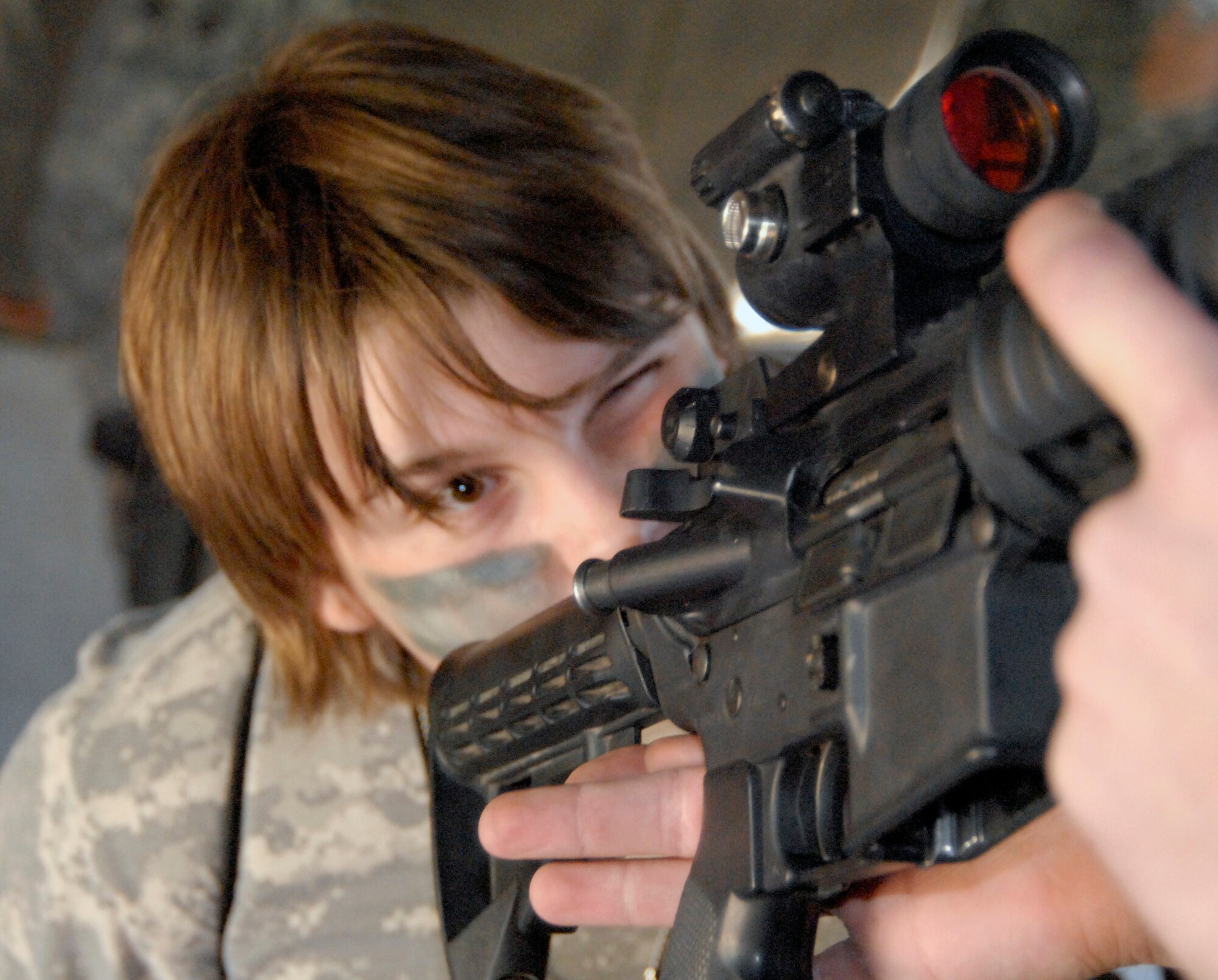 GOODFELLOW AIR FORCE BASE, Texas -- Caylan Kelly, 14, gets a glimpse of an M4 at Camp Discovery during Operation KIDS 2010 Nov. 13.  While at Camp Discovery, the youths received hands-on weapons training, spoke with Air Force Office of Special Investigations special agents and learned hand-to-hand fighting techniques from Army personnel.  (U.S. Air Force photo/Connie Hempel)