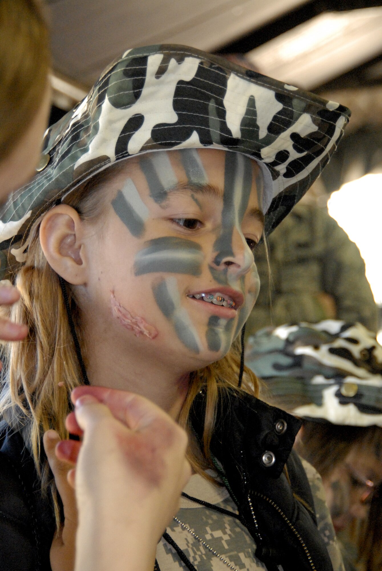 GOODFELLOW AIR FORCE BASE, Texas -- Tatiana Suchovsky, 10, gets moulaged at the medical tent at Camp Discovery during Operation KIDS 2010 Nov. 13.  While at Camp Discovery, the youths received hands-on weapons training, spoke with Air Force Office of Special Investigations special agents and learned hand-to-hand fighting techniques from Army personnel.  (U.S. Air Force photo/Connie Hempel)