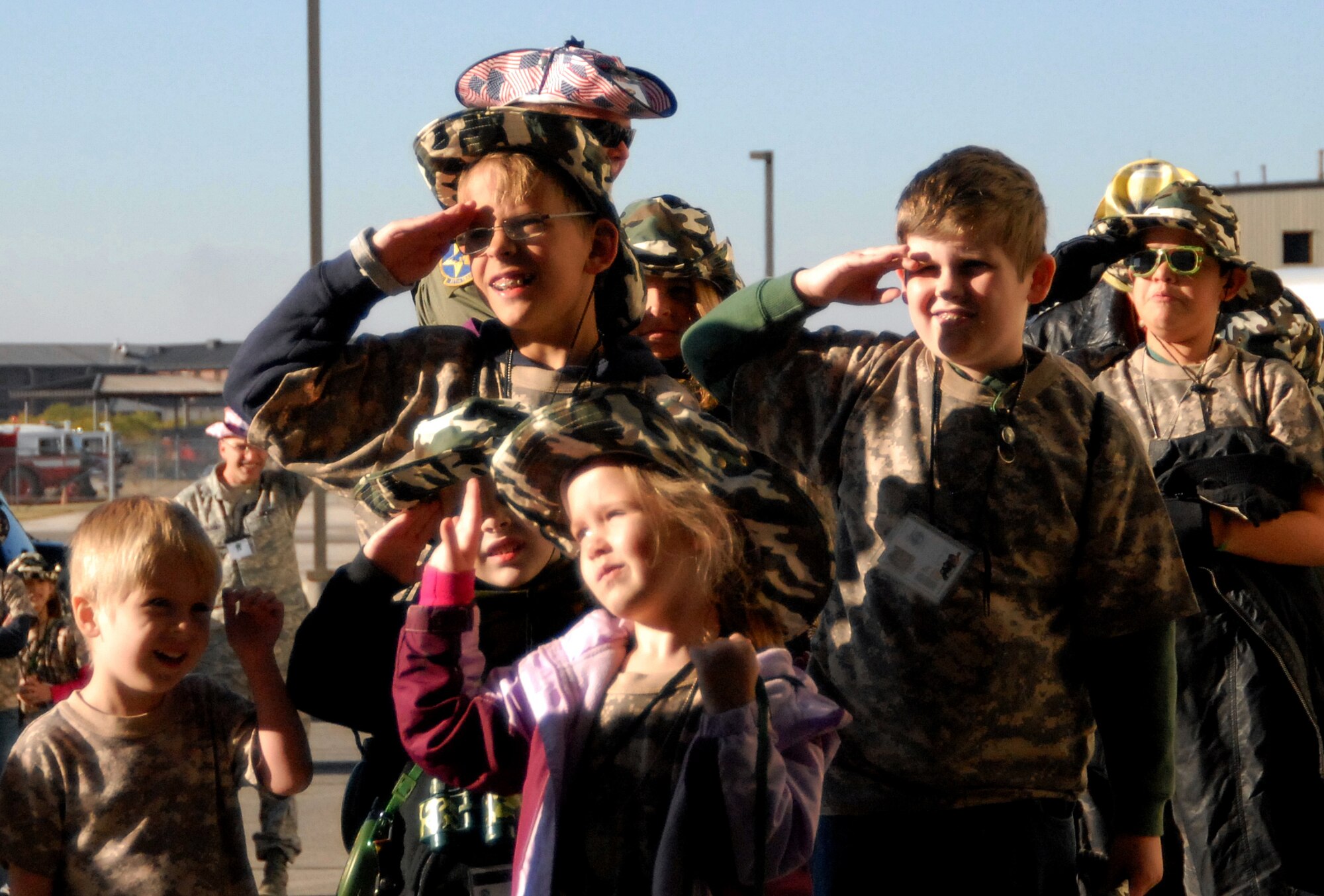 GOODFELLOW AIR FORCE BASE, Texas -- Before entering the deployed air base, youths with Operation KIDS learn how to salute when encountering an officer.  At the deployed air base (the 312th Training Squadron High Bay) the youths completed a Marine Corps obstacle course, went through a confined space tunnel and were instructed on proper use of various fire rescue vehicles.  (U.S. Air Force photo/Connie Hempel)