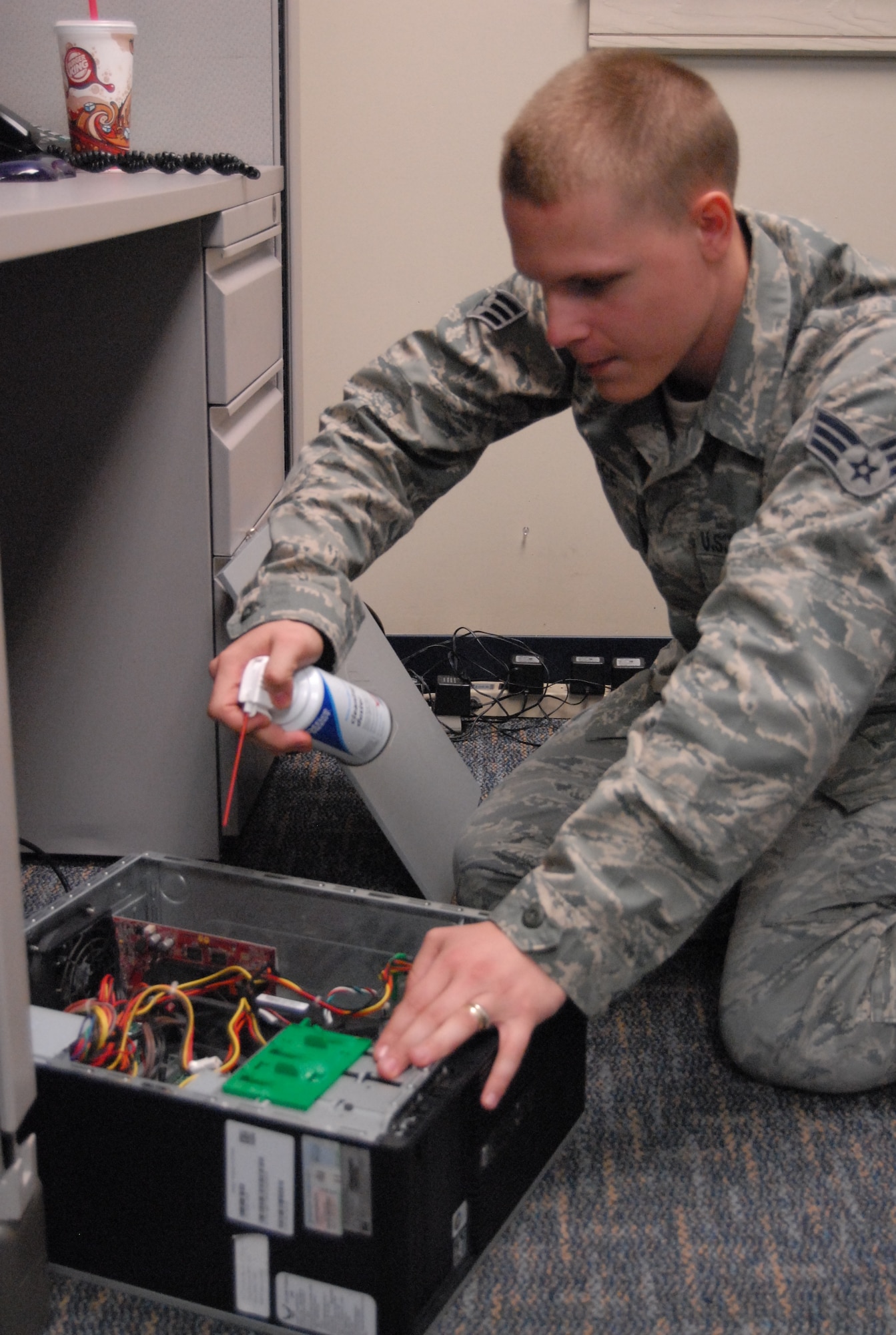 Senior Airman Thomas Vance, 43rd Communications Squadron air blasts the dust out of a computer before replacing a hard drive. Airman Vance is a Client Systems Administrator, whose primary responsibility is trouble shooting network issues and reconfiguring core programs on government computers. (U.S. Air Force photo/Airman 1st Class Kate Wetherby)