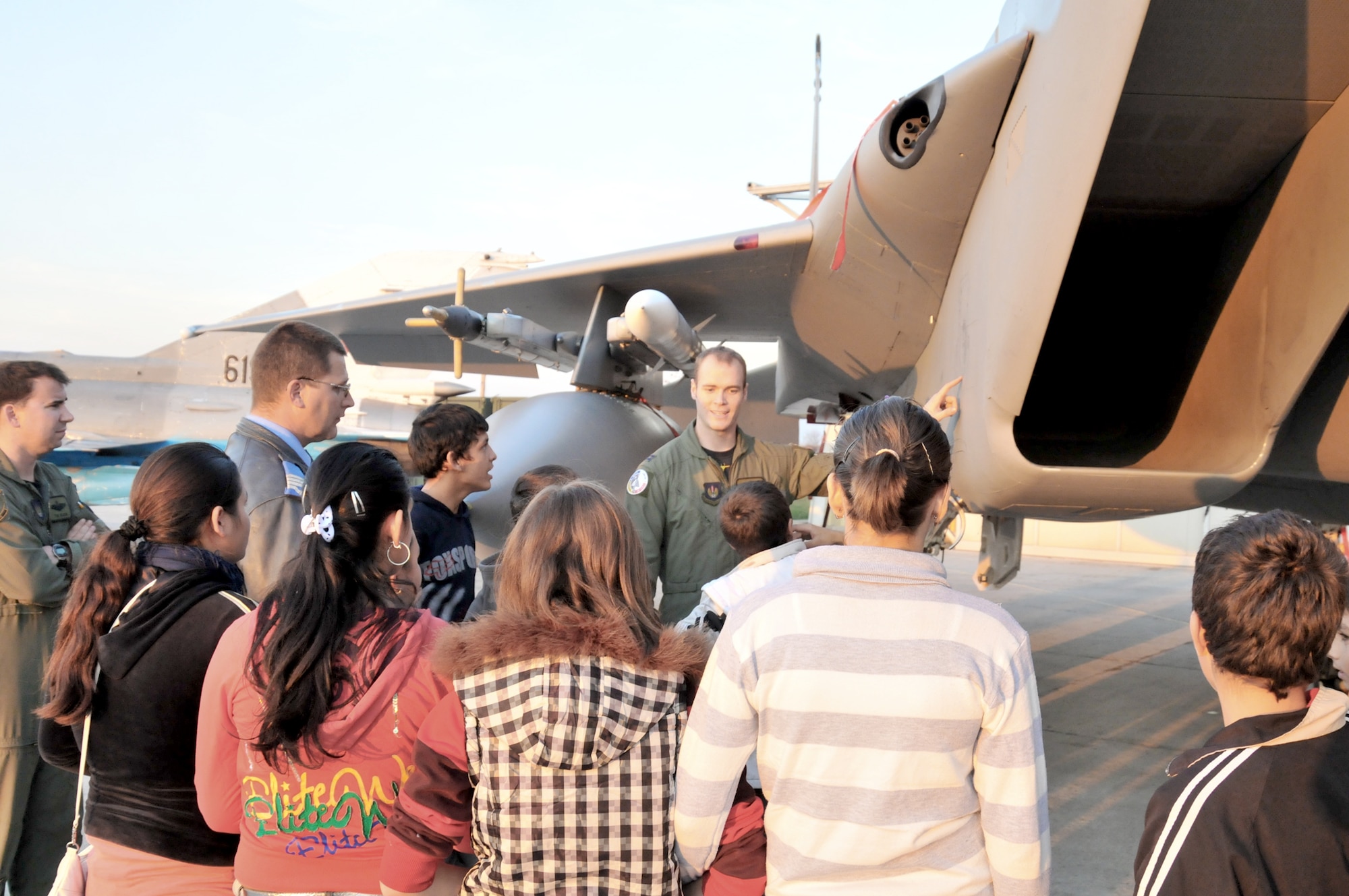 Capt. Neils Barner describes an F-15C Eagle to a group of Romanian school children Nov. 5, 2010, at Campia Turzii Air Base, Romania. The children visited from a local youth center where Airmen had volunteered to play games and perform repairs. Captain Barner is a pilot with the 493rd Fighter Squadron. (U.S. Air Force photo/Senior Airman David Dobrydney)