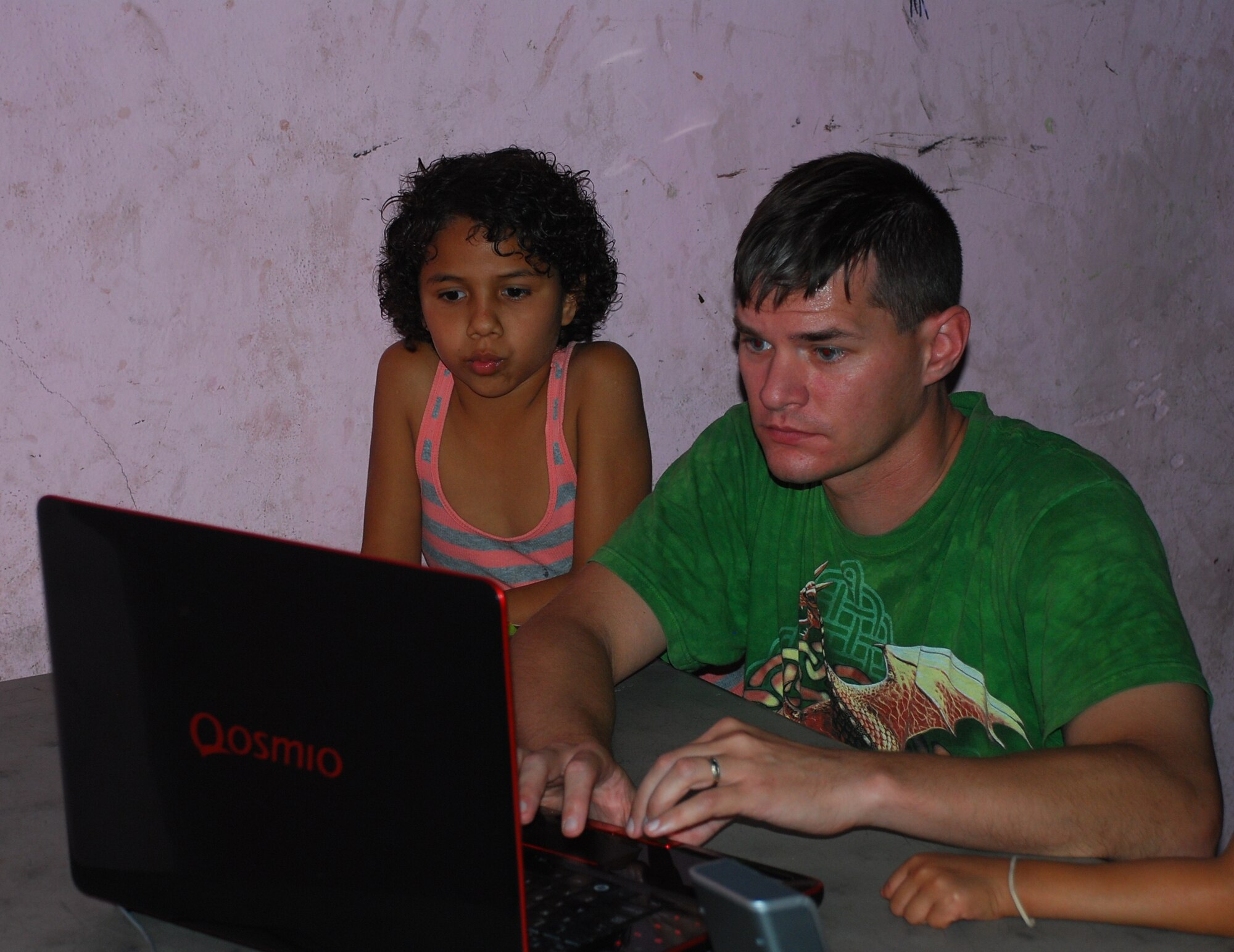 SOTO CANO AIR BASE, Honduras - U.S. Air Force Tech. Sgt. Mike Skidmore plays a movie on his computer for children at the Hogar Tierra Santa Orphanage, Sunday, 14 Nov 2010.  20 members of the Joint Task Force-Bravo team visited the children to serve them dinner, bring clothing and participate in games and laughter.  The Tierra Santa Orphanage is just one of several that are sponsored by members of JTF-B. (U.S. Air Force photo/Capt. John T. Stamm)