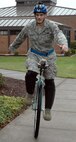 JOINT BASE LEWIS-MCCHORD, Wash., - Master Sgt. Shannon Barry, an aircraft maintenance technician with the 446th Aircraft Maintenance Squadron, shows off his unicycle talent in front of the wing headquarters building on Nov. 6.  Sergeant Barry, a native of Steilacoom, Wash., said learning to ride the unicycle has greatly improved his recovery from knee surgery.  (U.S. Air Force photo/Staff Sgt. Grant Saylor)
