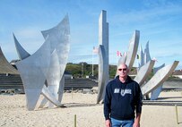JOINT BASE LEWIS-MCCHORD, Wash., - Lt. Col. Pat Kearney, 446th Airlift Wing, stands in front of Les Braves at Omaha Beach, Normandy, France. Les Braves is the memorial marking the spot where the main beach assault took place on D-Day, June 6 1944. (Courtesy photo)