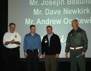 JOINT BASE LEWIS-MCCHORD, Wash.- Col. William Flanigan, 446th Airlift Wing commander, right, holds a $4,000 check presented by members from the Hawks Prarie Rotary in Lacey, Wash. Josepth Beaulieu, Dave Newkirk, and Andrew Oczkewicz were the presenters who donated the check to support the wing Care and Share Program. Care and Share is run by the 446th Mission Support Group Airmen and Familiy Readiness Center to help families from the wing who need a little extra help during the holiday season. (U.S. Air Force photo/Staff Sgt Javier Cruz)